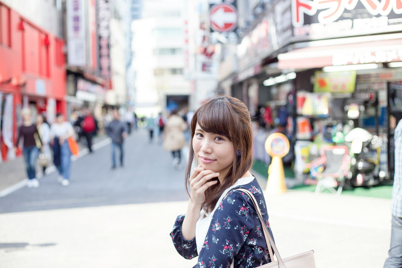 Une femme souriante regardant la rue autour d'elle