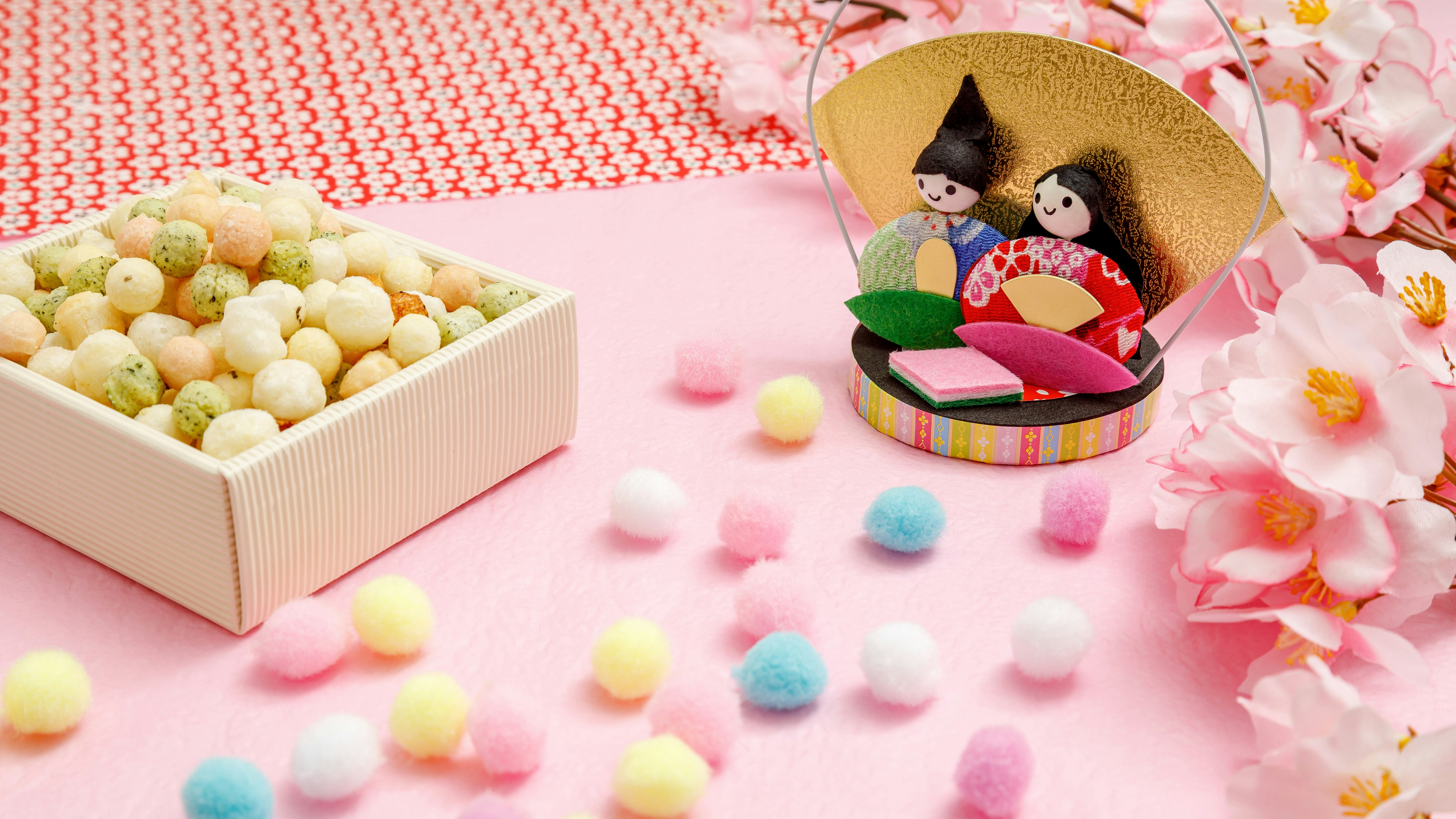 ピンクの花びらとカラフルな菓子が並ぶ春のデコレーション