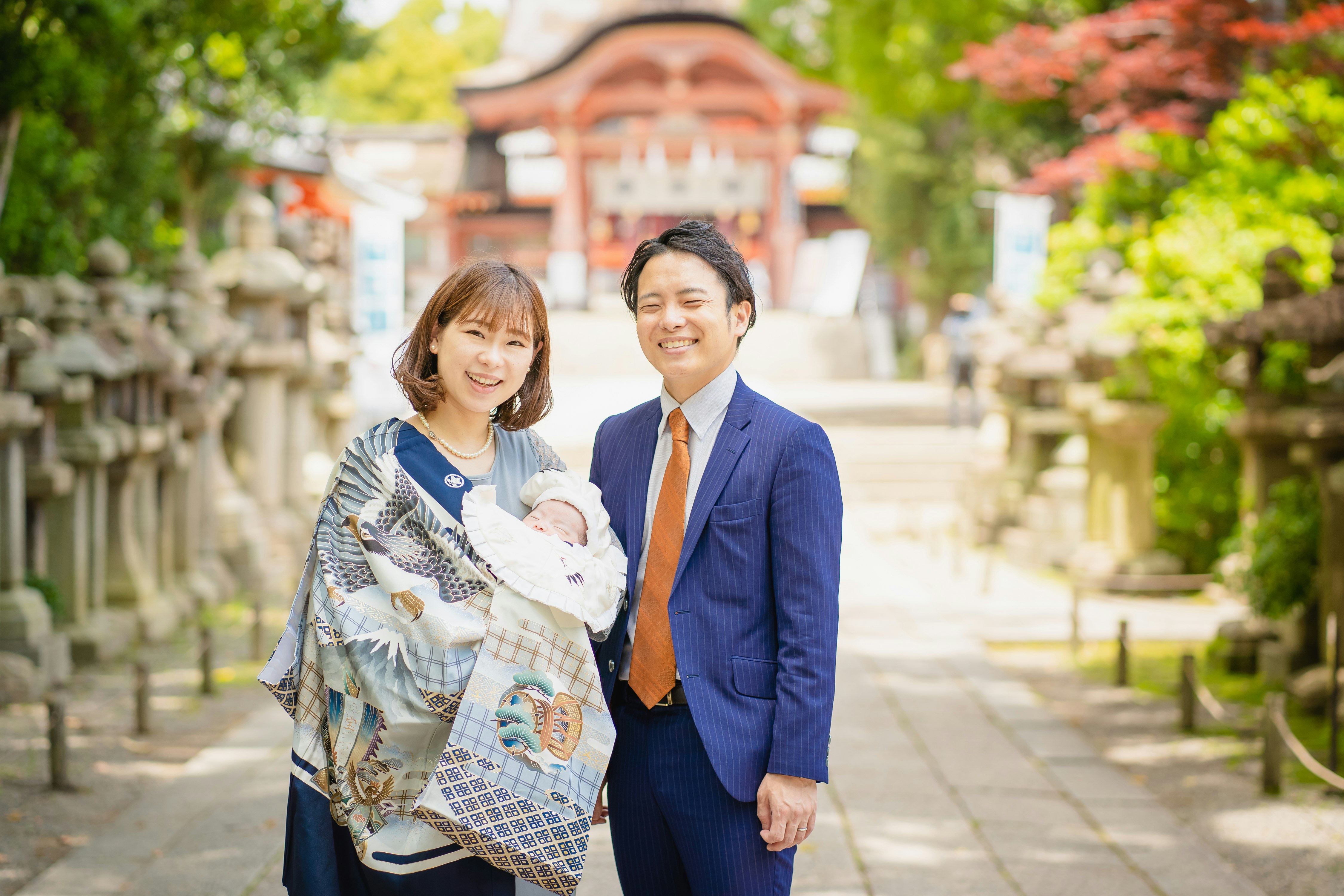 お宮参りの家族が参道で記念撮影する様子