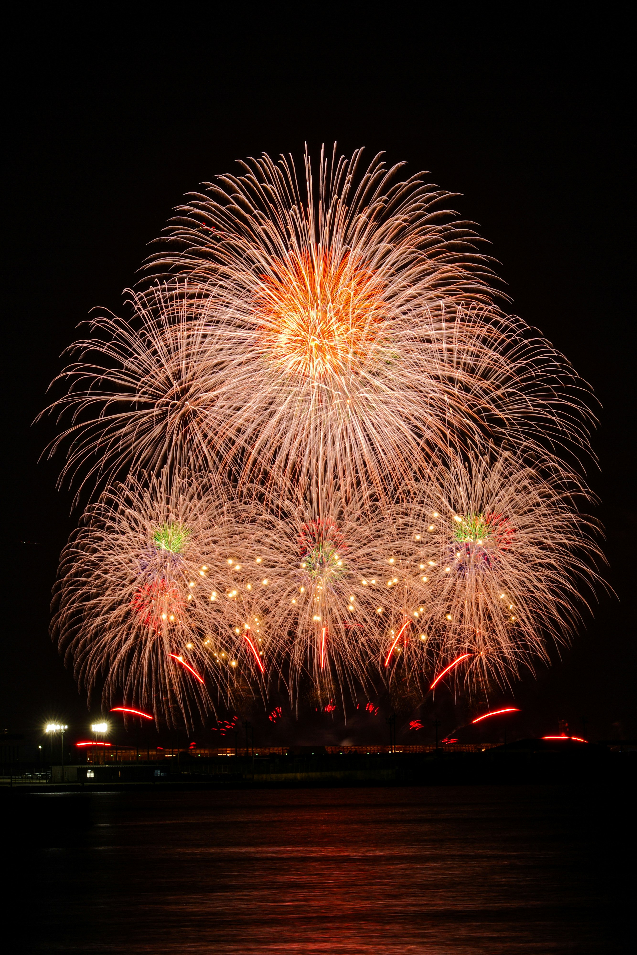 大阪・関西万博の花火が夜空に広がる海辺の光景