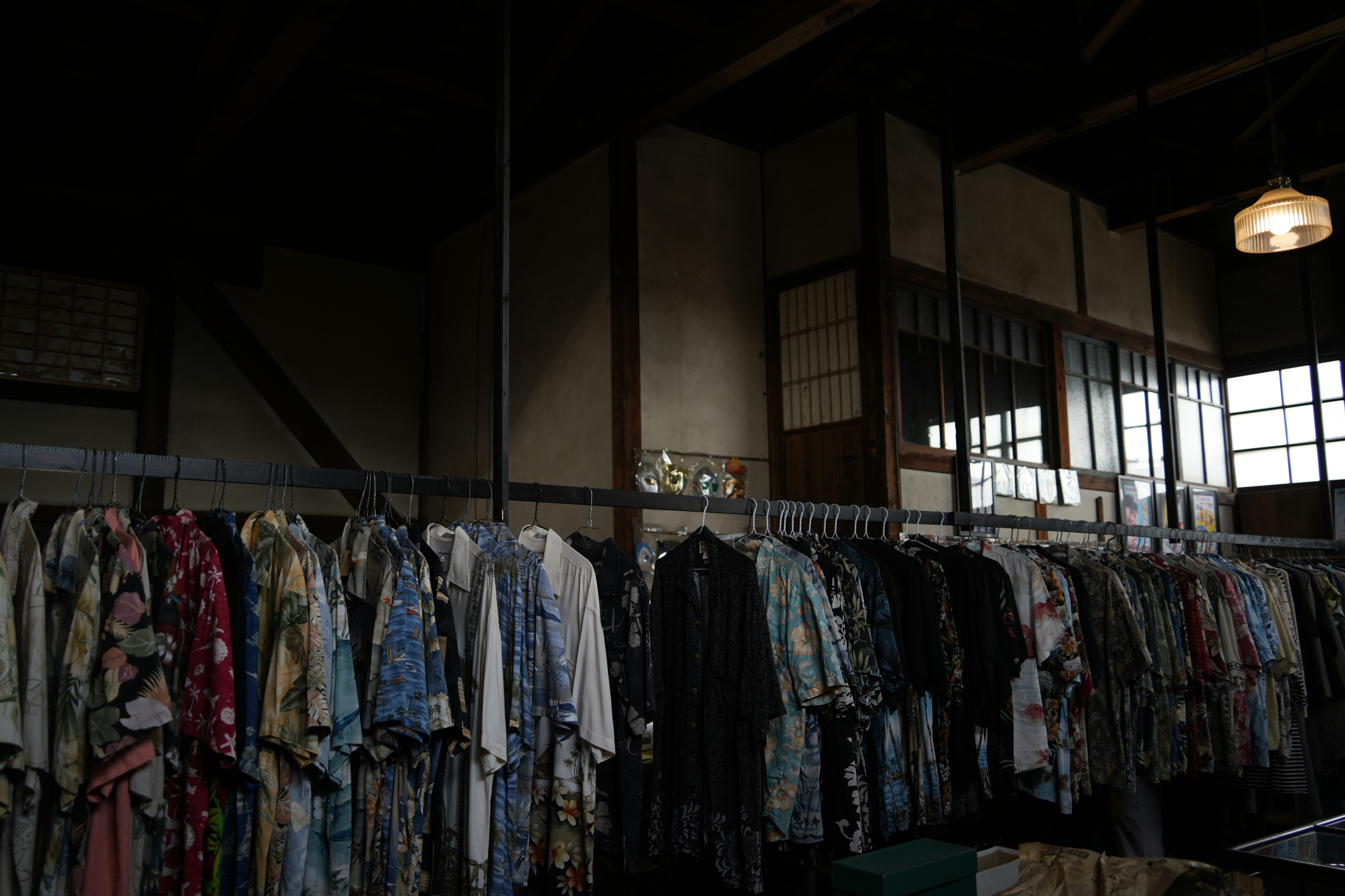 Innenraum eines Vintage-Kleidungsgeschäfts mit Reihen von Kleidungsstücken auf Bügeln