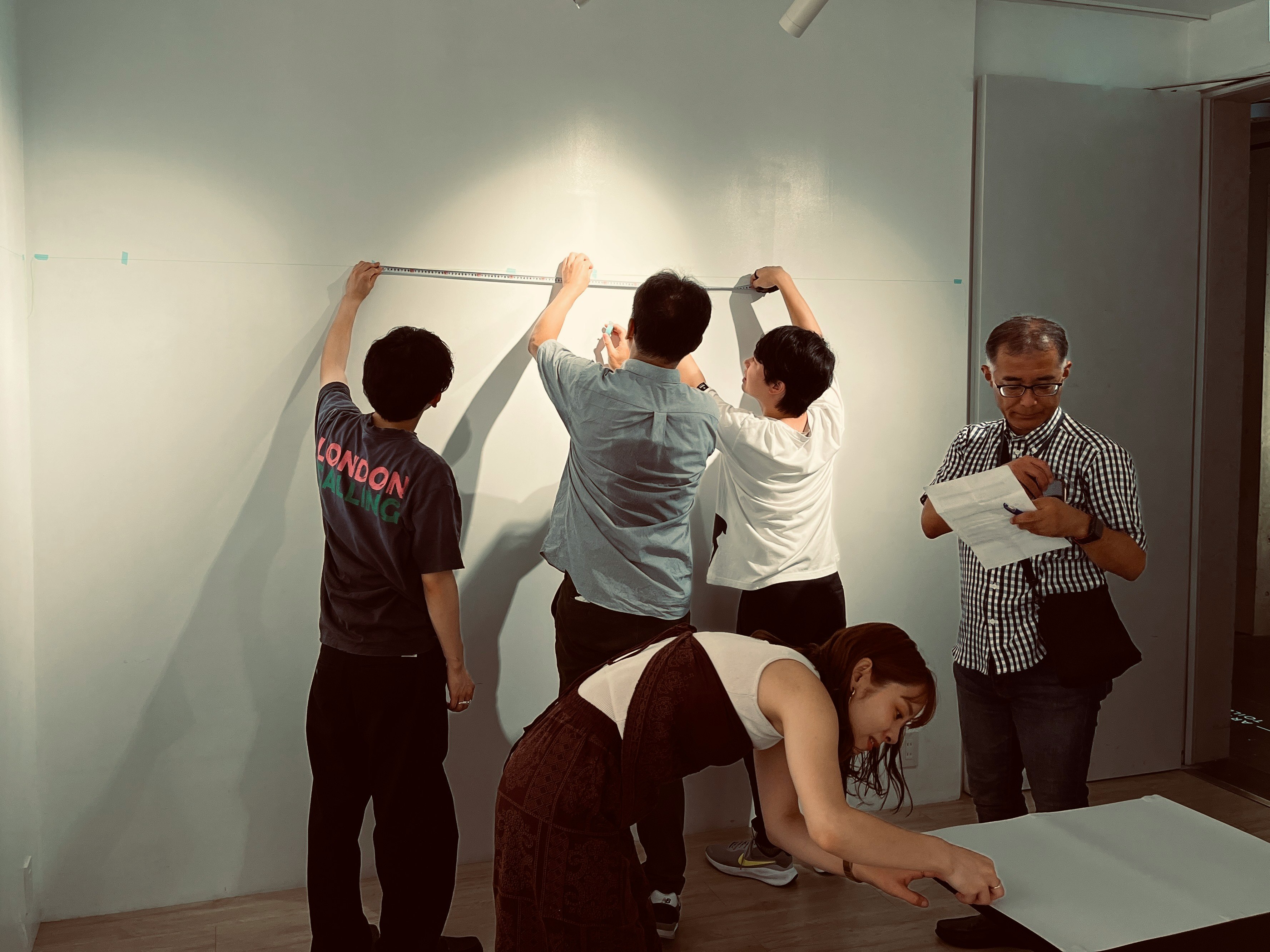 人们在白色墙面上安装大张纸