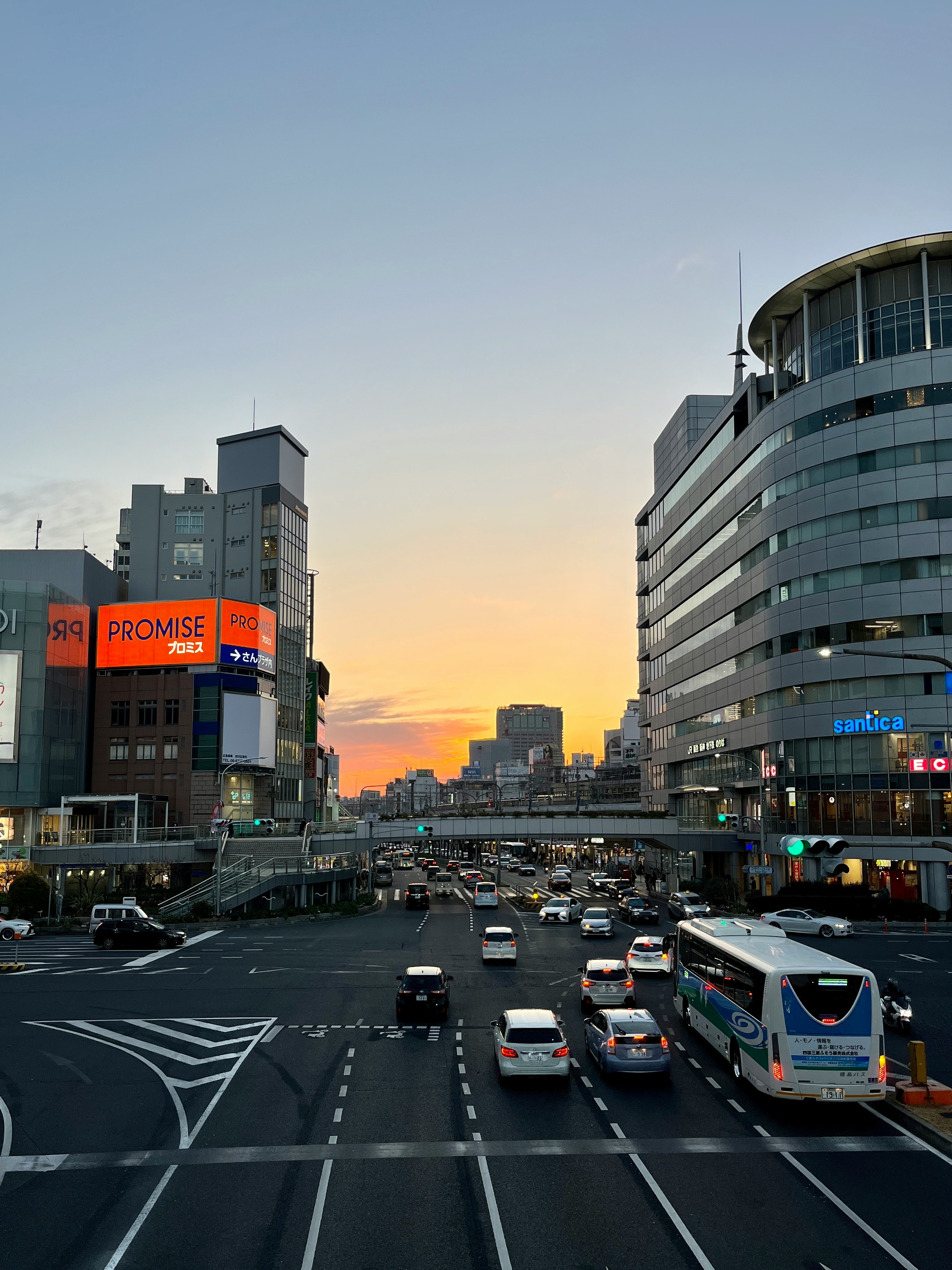 夕焼けの街並みと幹線道路を走る車のある都市風景