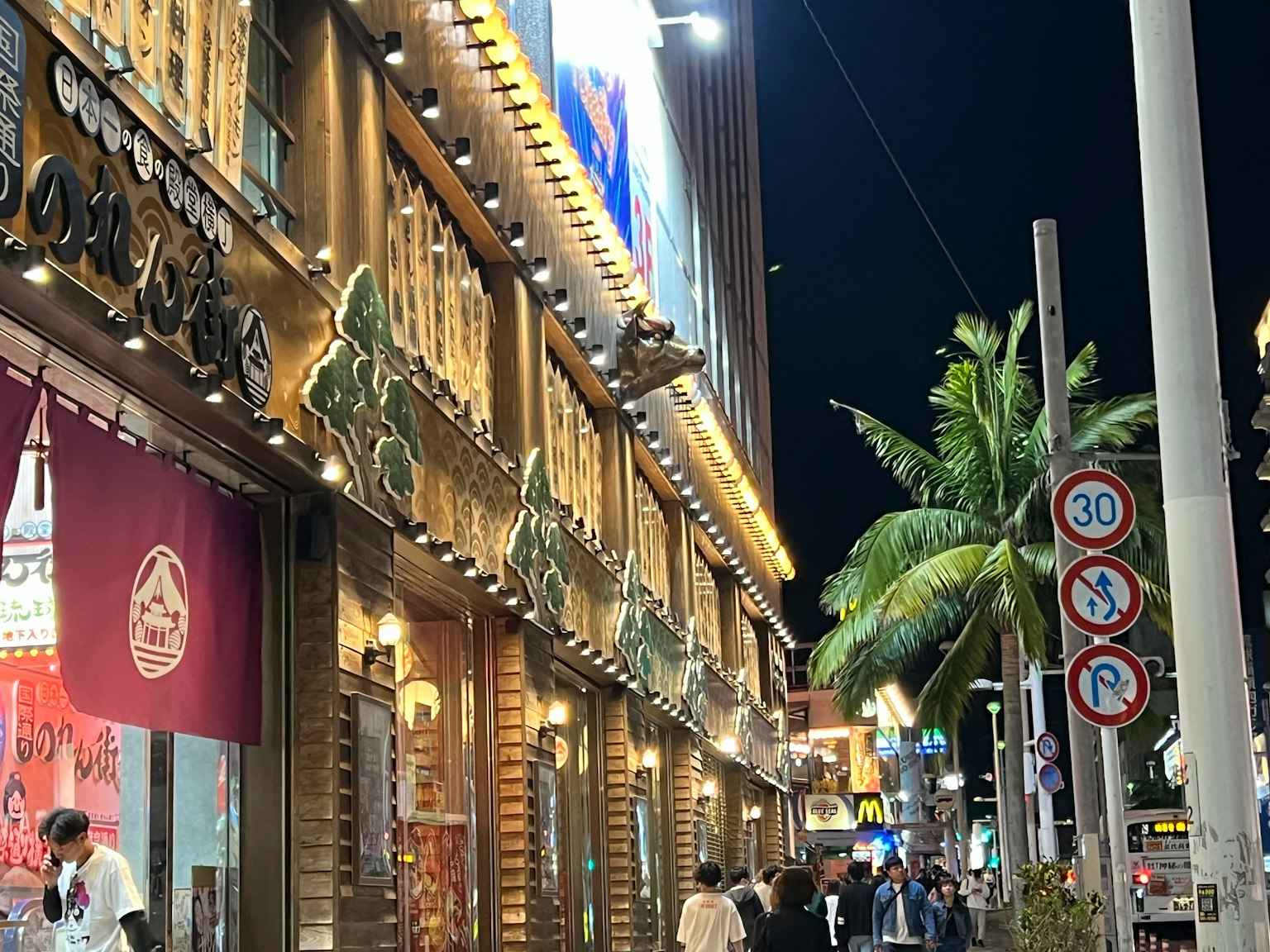 Goldenes Gebäude mit hellen Schildern in einer lebhaften nächtlichen Szene
