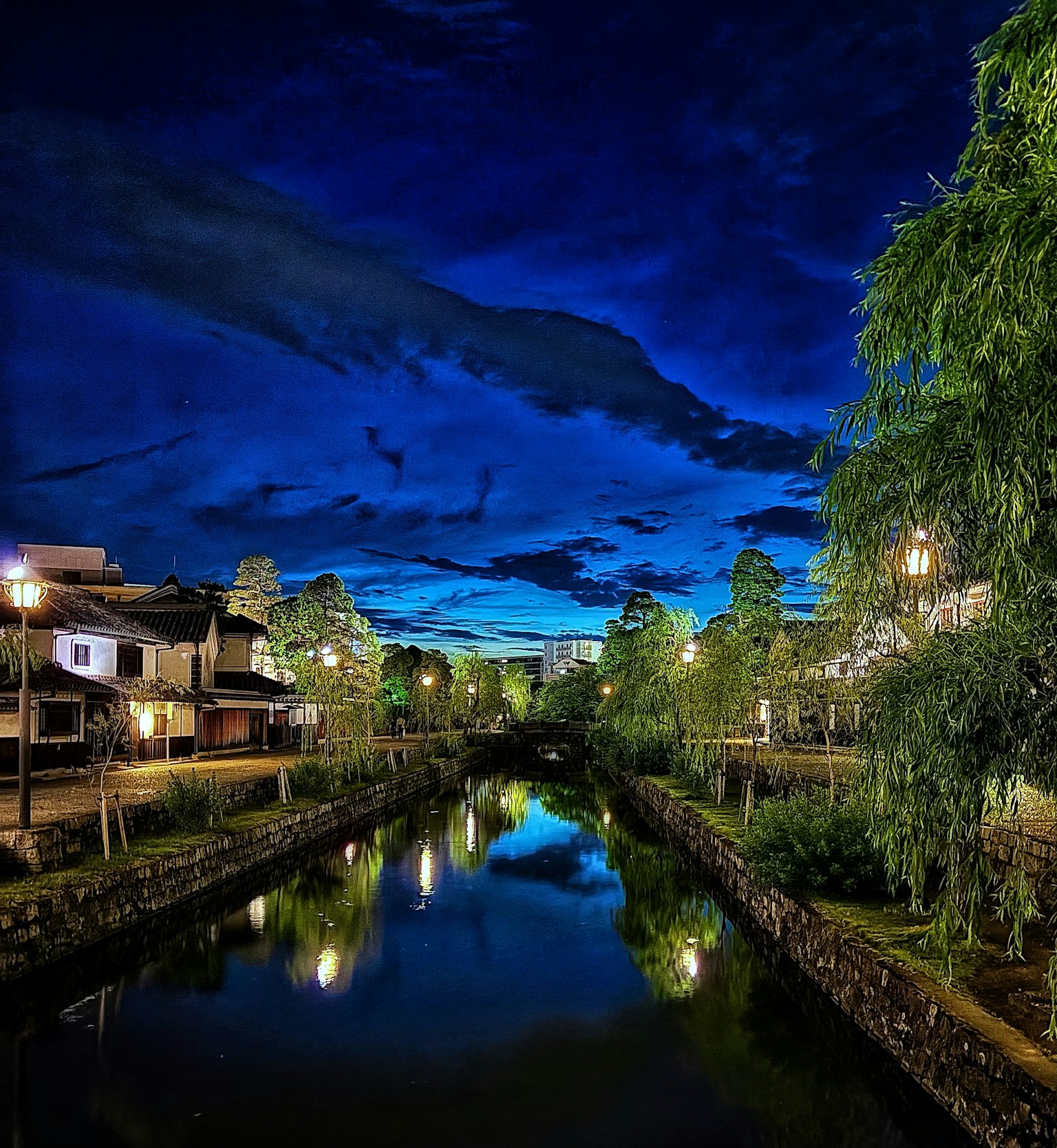 Pemandangan sungai yang indah di malam hari dengan bangunan di sekitarnya dan langit yang cerah