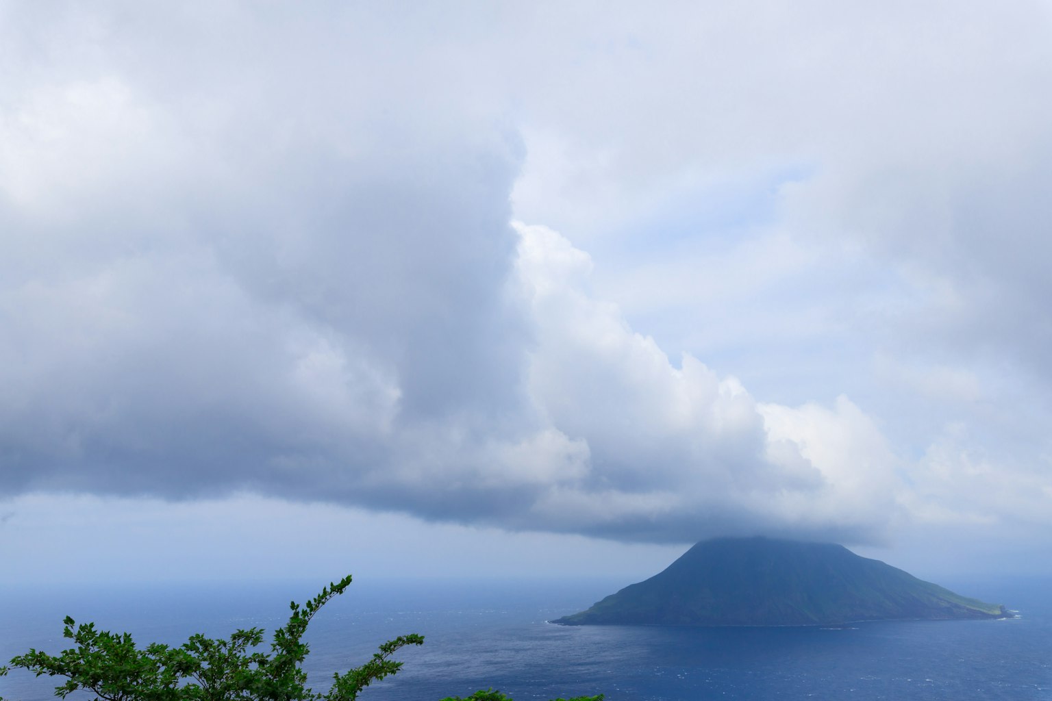 Insel von Wolken bedeckt mit Blick auf den blauen Ozean