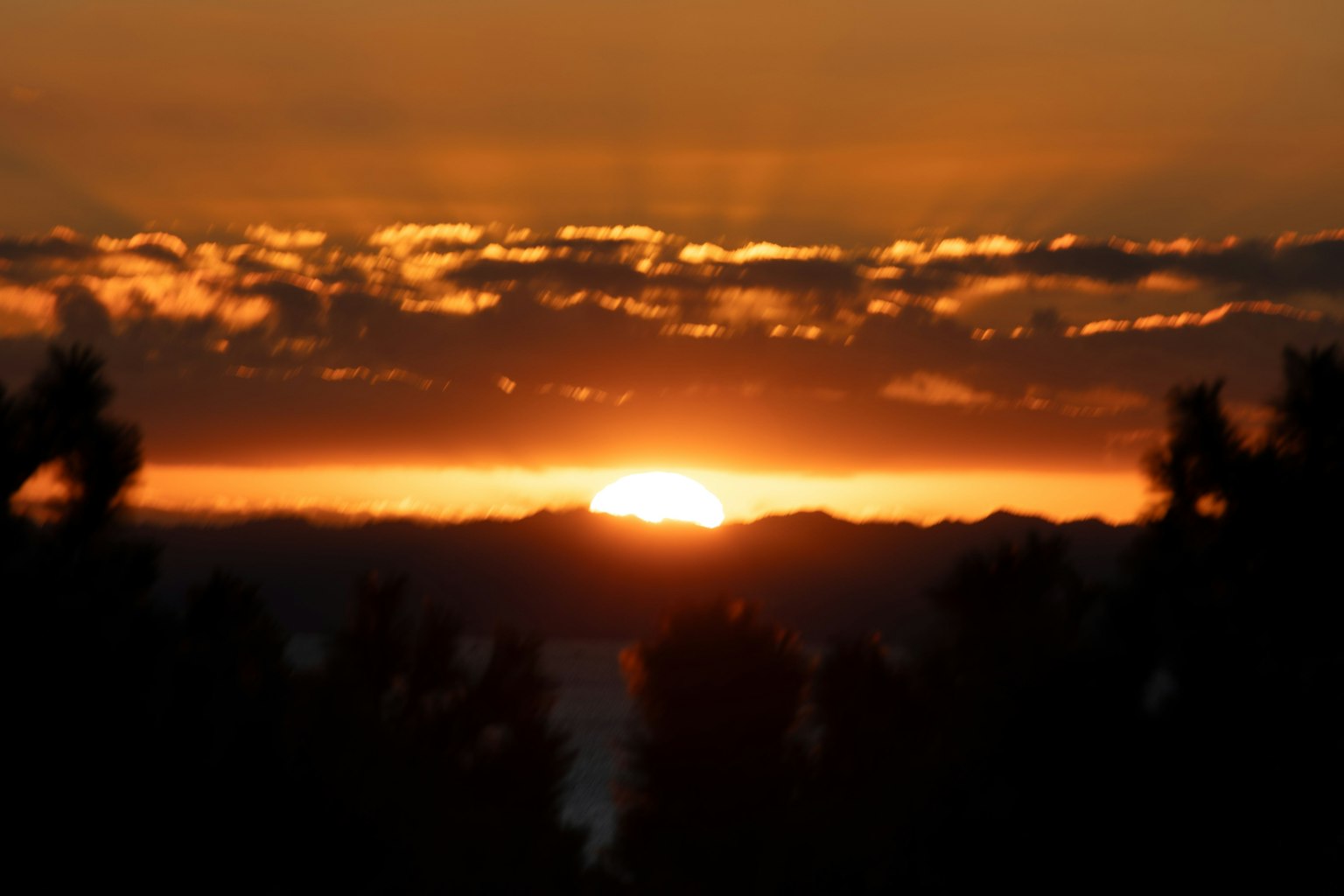 Bellissimo tramonto sulle montagne con vivaci tonalità di arancione e giallo