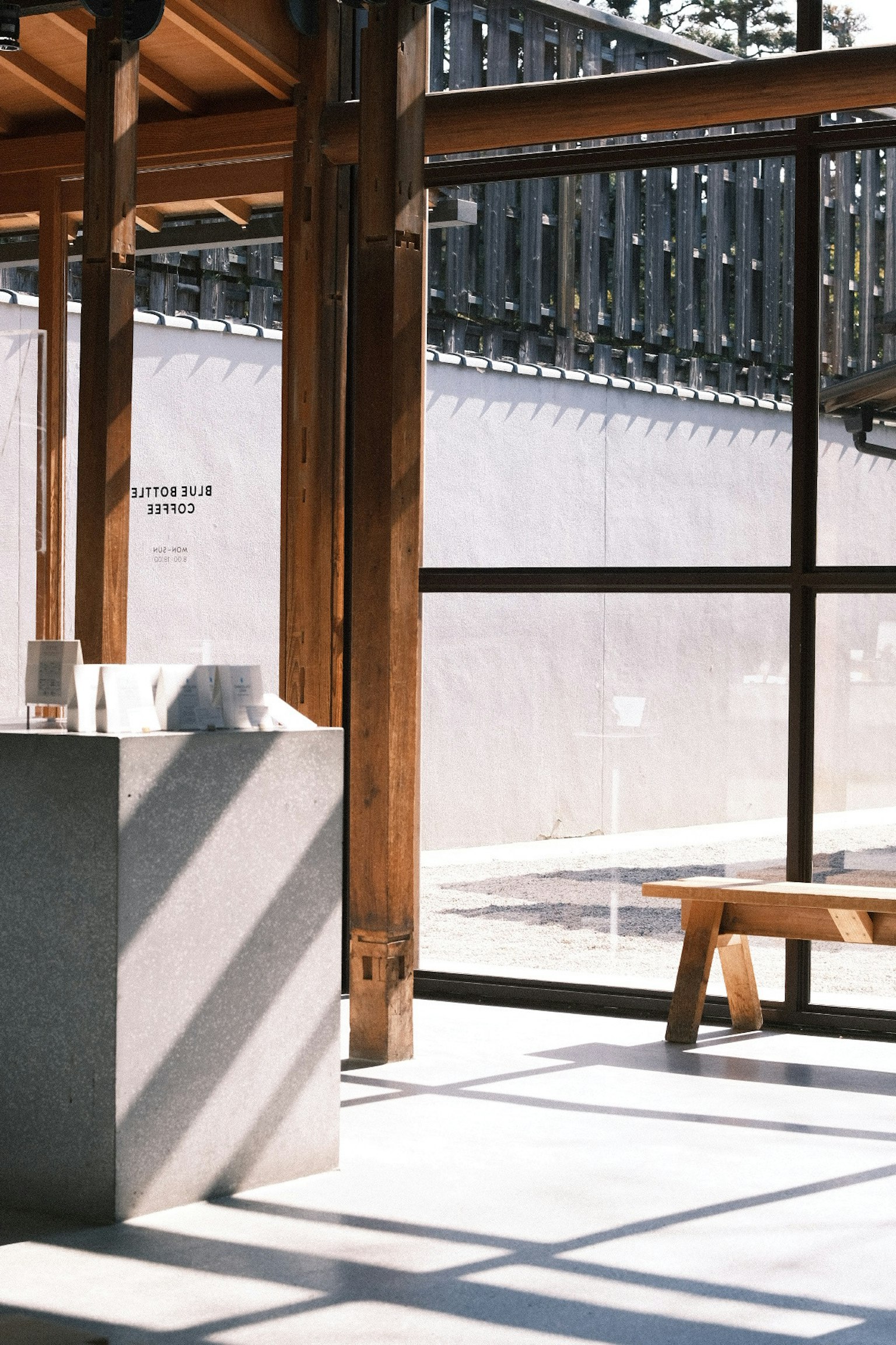 Không gian nội thất hiện đại với cấu trúc gỗ và cửa sổ lớn Bóng đổ trên tường và sàn trắng