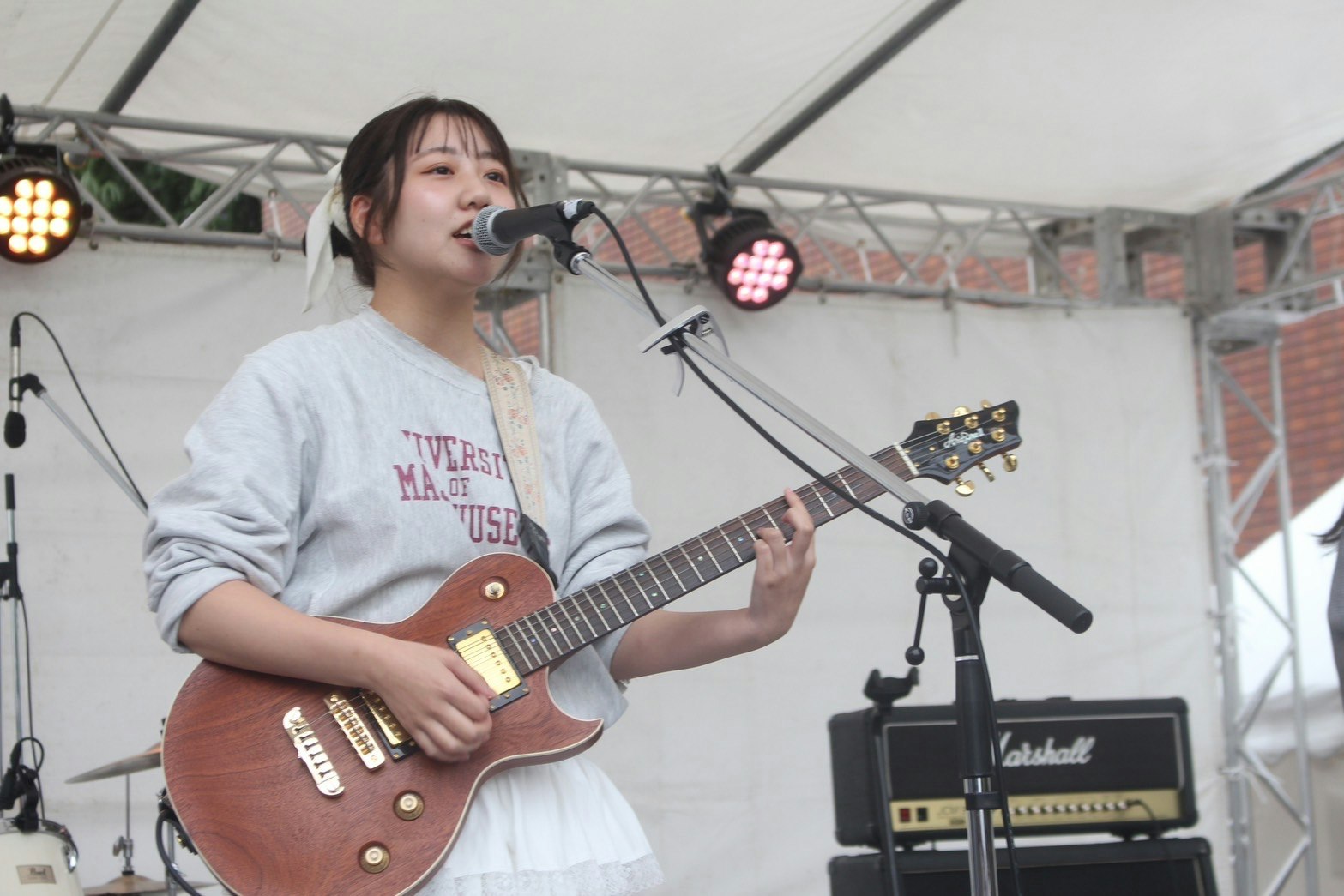 舞台上彈吉他並演唱的女性