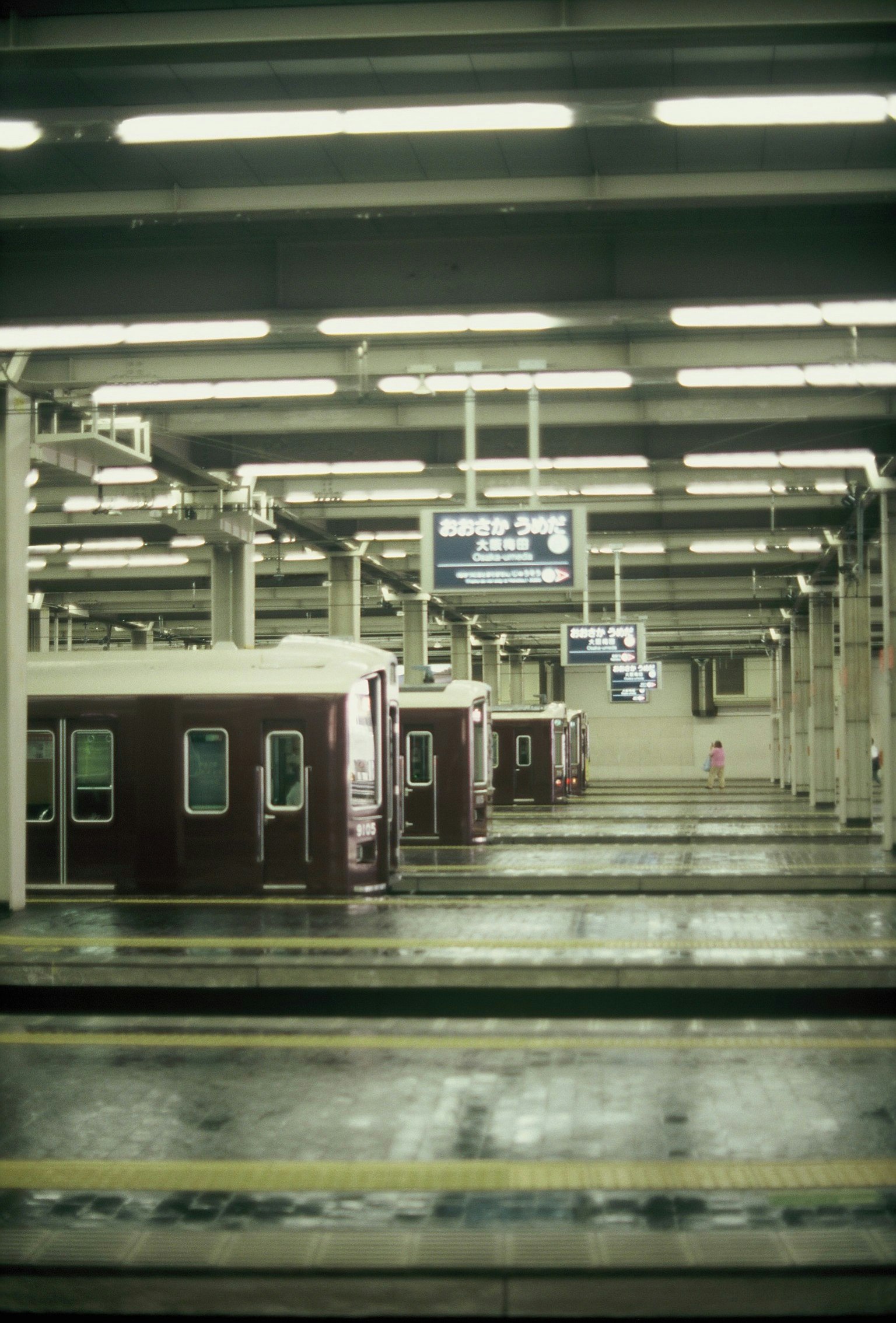 Plateforme de station de métro calme avec des voitures de train rouges et un éclairage lumineux