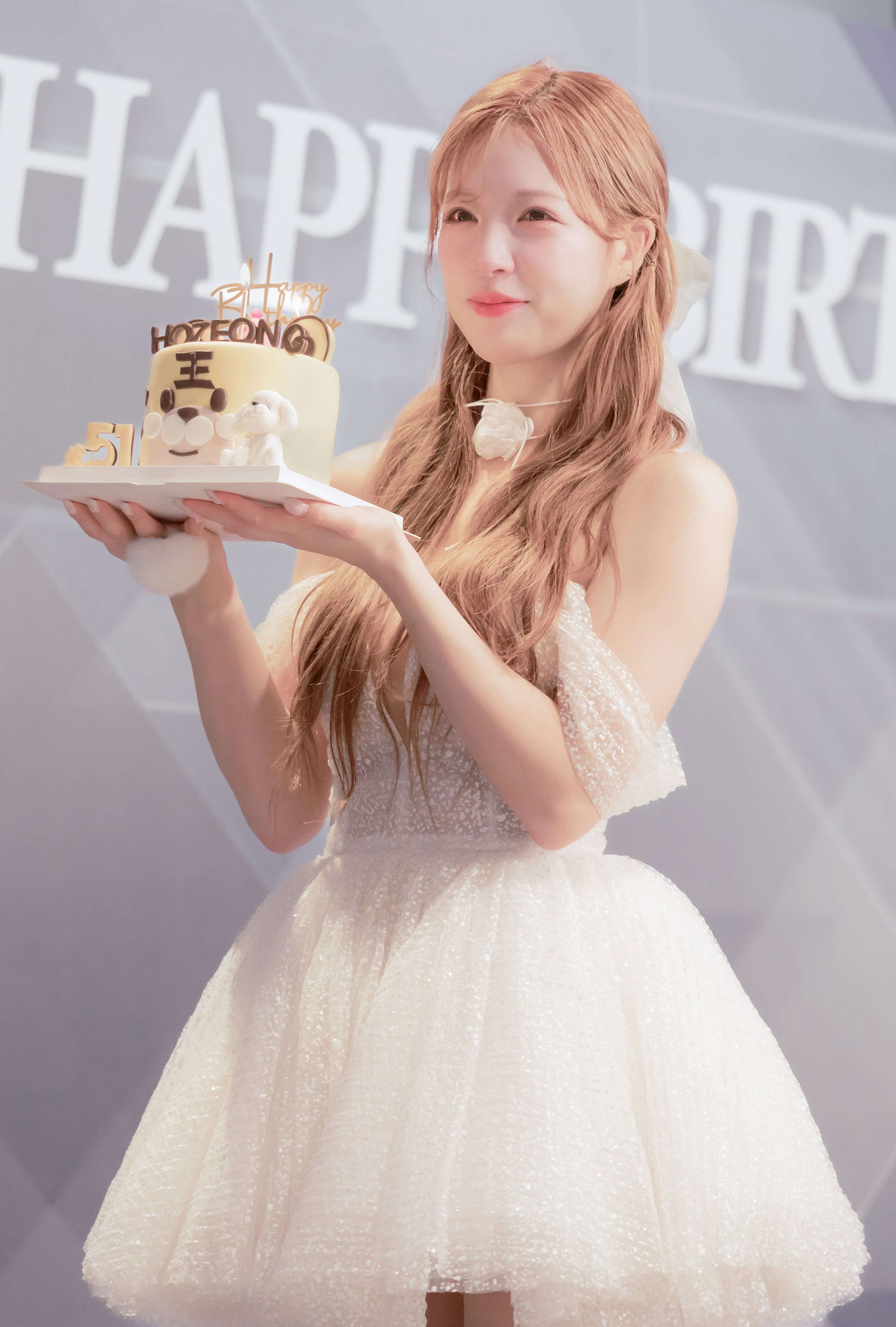 ケーキを持つ笑顔の女性とバナー背景のイベント会場
