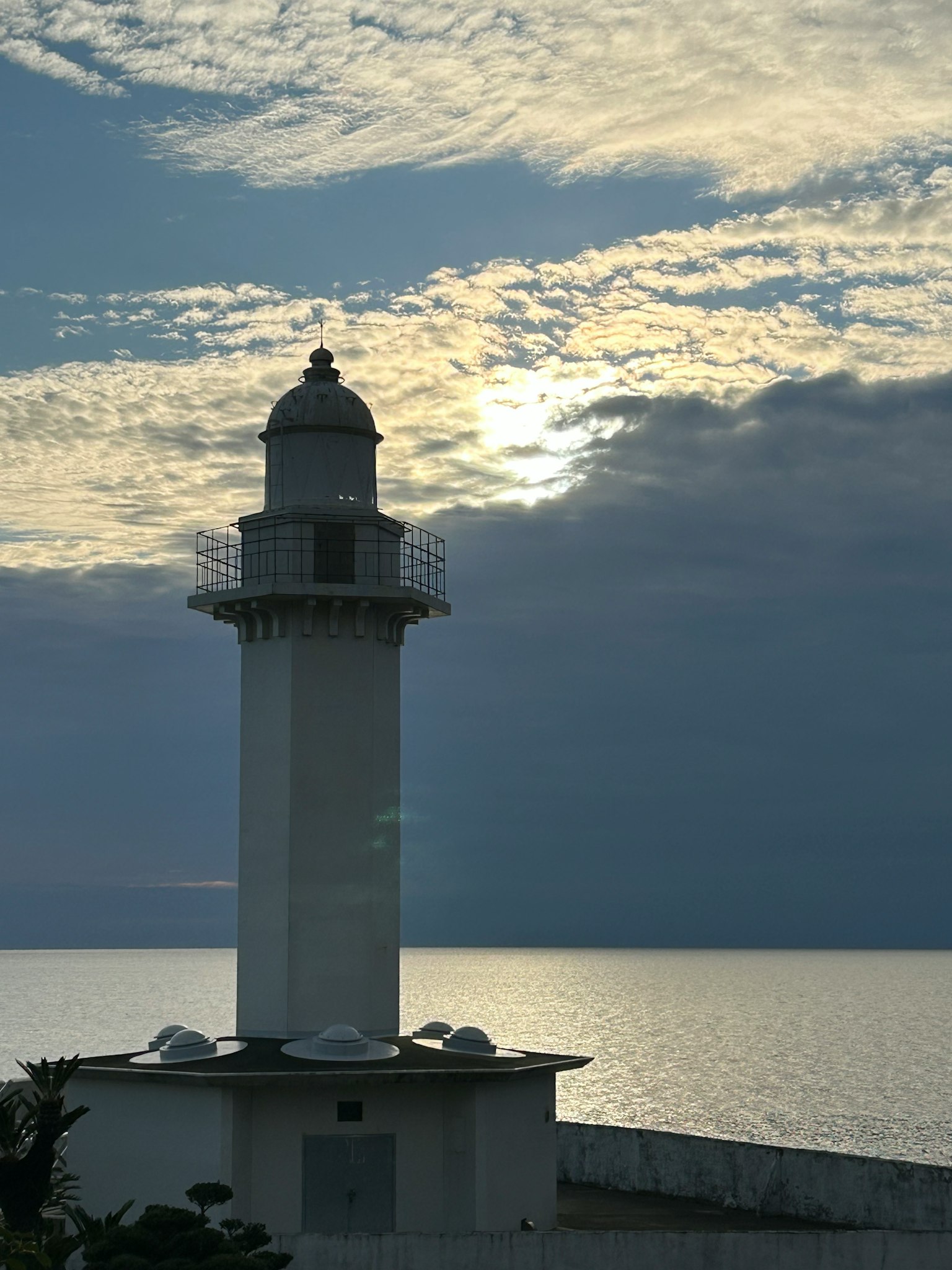 Mercusuar di tepi laut di bawah langit mendung