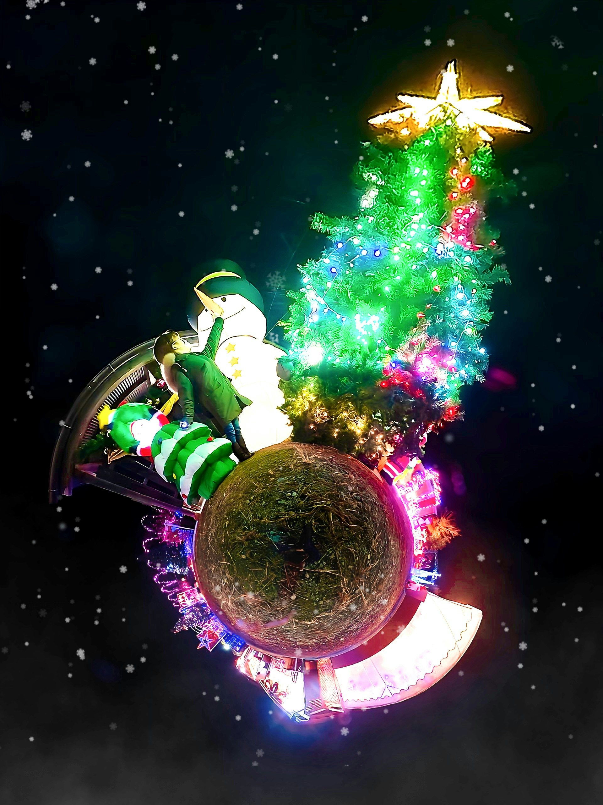 夜空の下で光るクリスマスツリーと雪のような演出