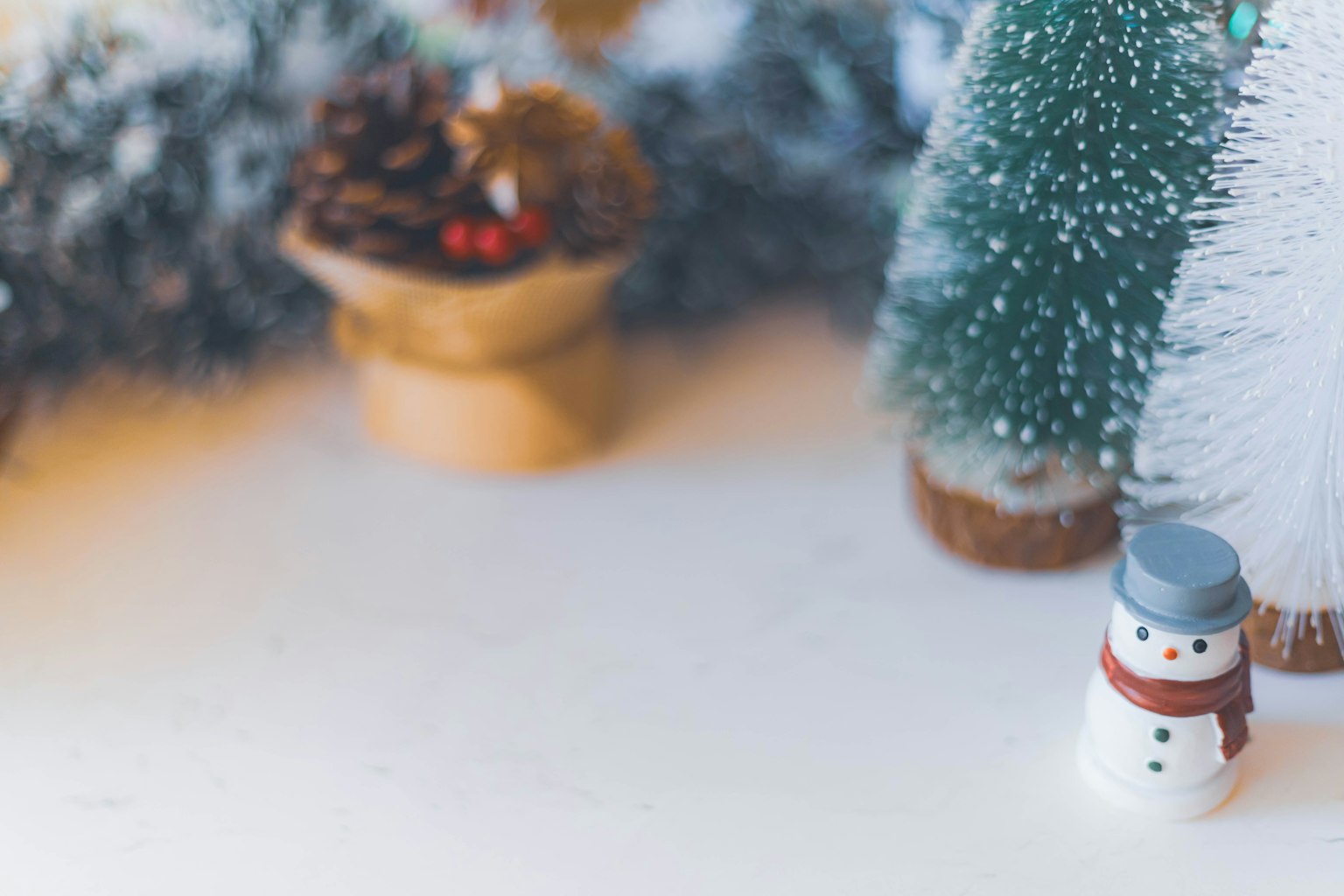 Sebuah pemandangan musim dingin dengan seorang manusia salju dan pohon Natal yang didekorasi