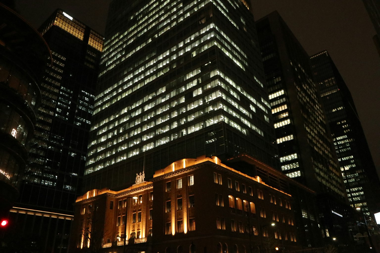 Sự tương phản của các tòa nhà chọc trời sáng ánh đèn và một tòa nhà lịch sử trong cảnh quan thành phố ban đêm