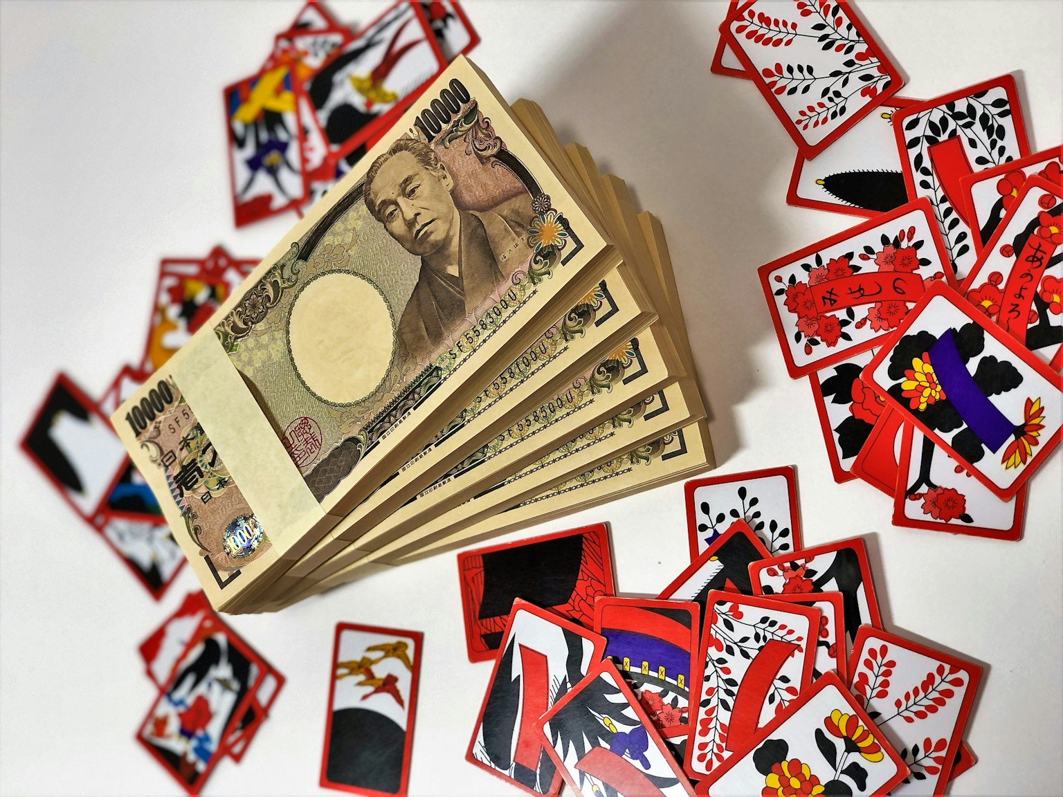 日本貨幣與周圍散落的彩色撲克牌