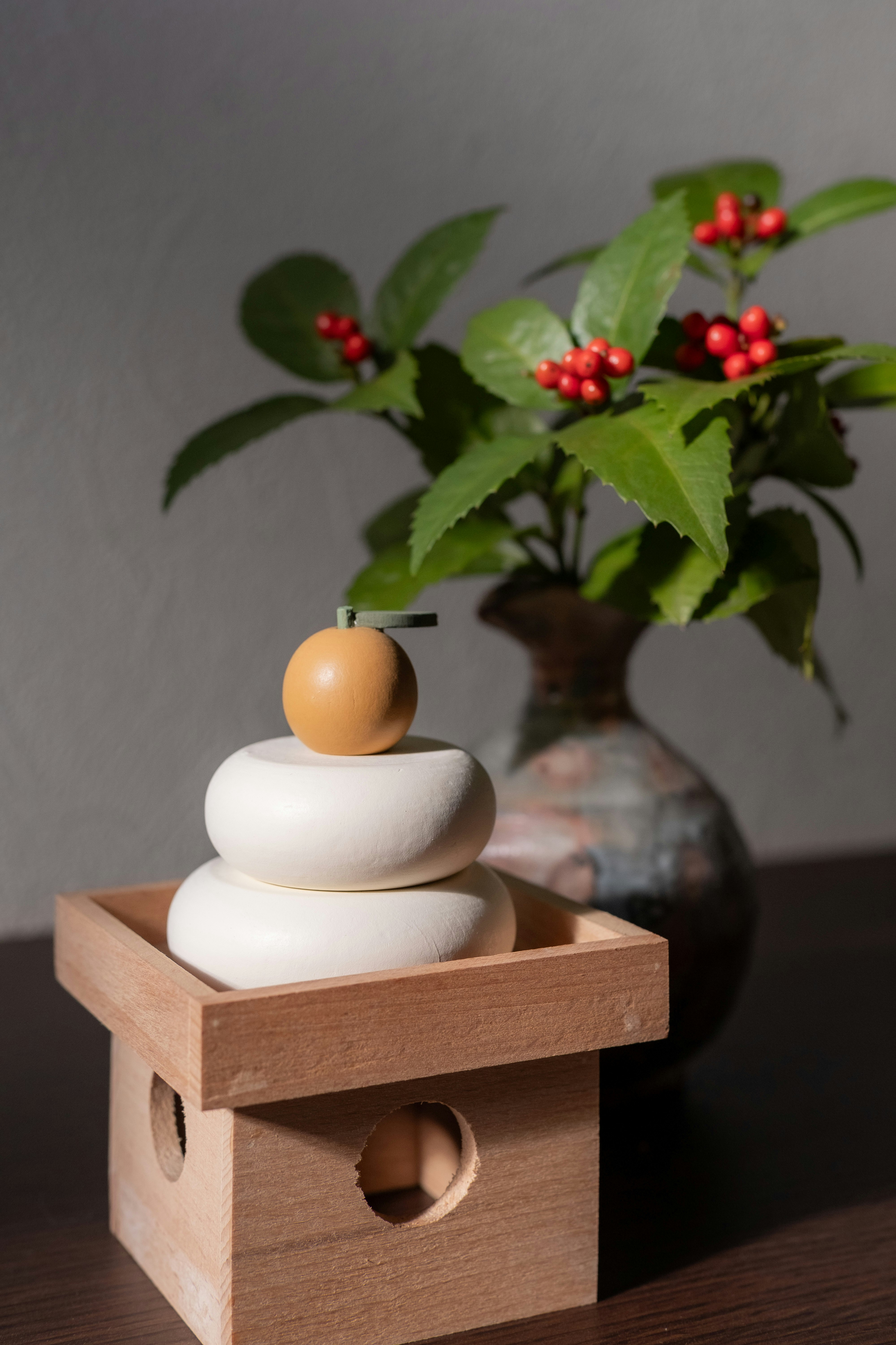 木箱の上の白い花器と丸い置物