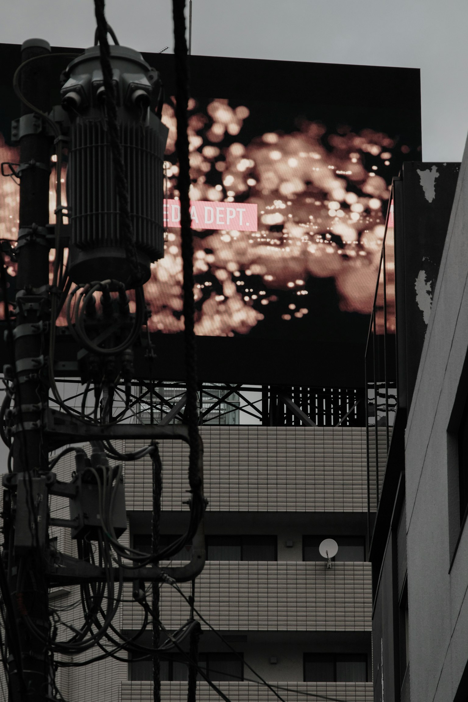 Bright billboard with abstract lights against a dark background and intersecting power lines