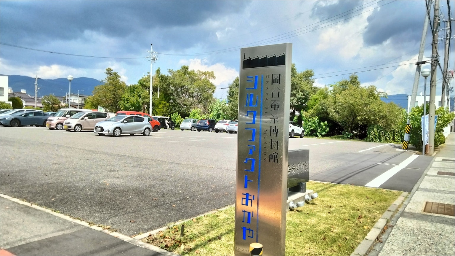 停车场标志与周围绿化和多云的天空