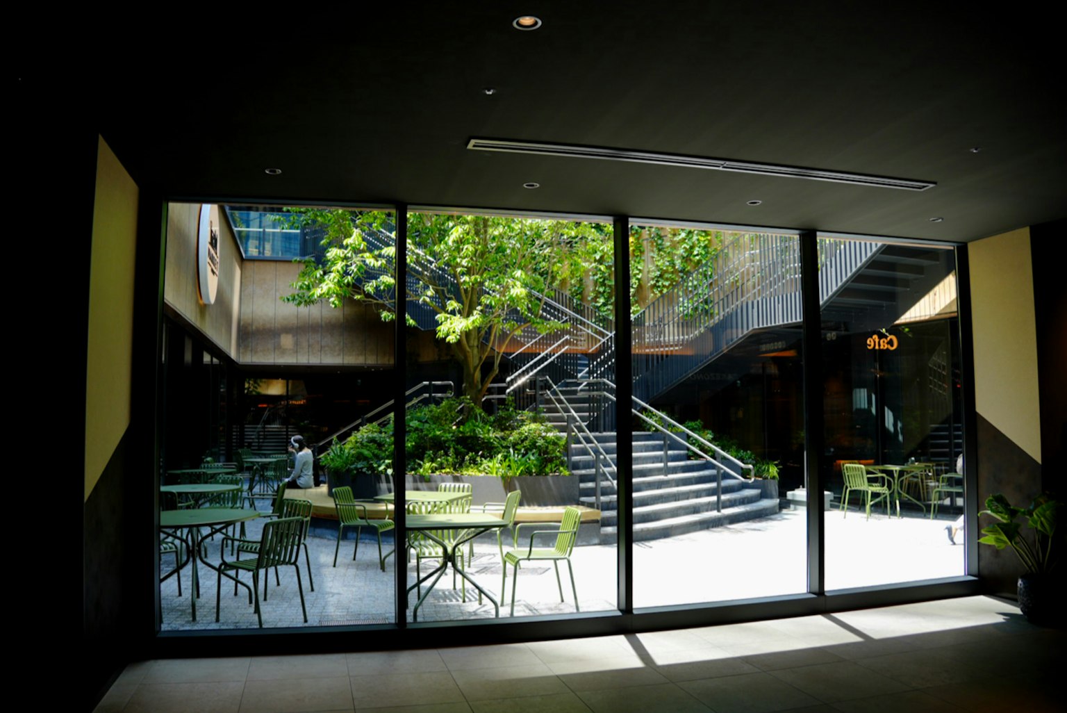 Bright interior view showcasing a lush courtyard and staircase