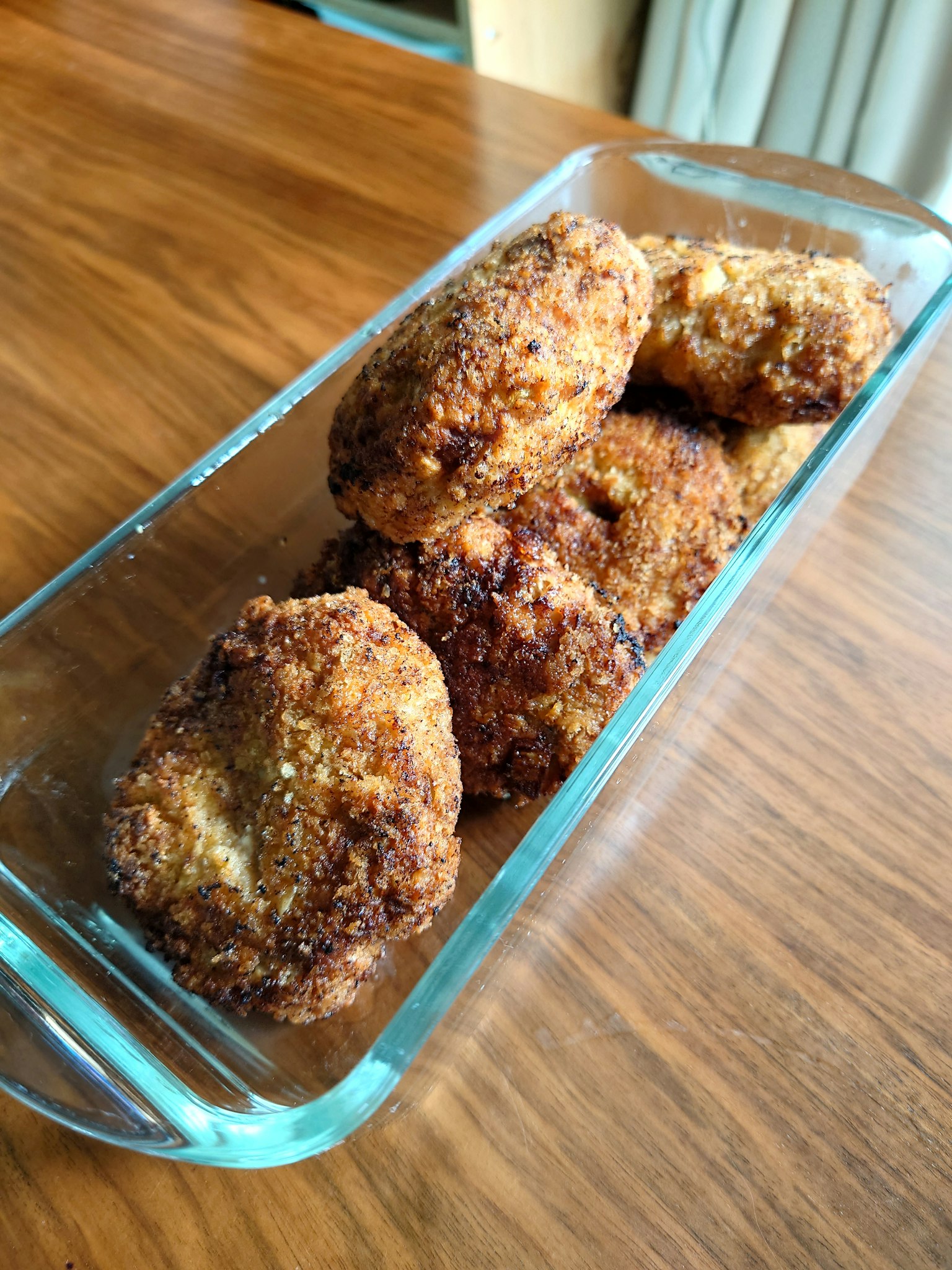 酥脆的可樂餅放在木桌上的玻璃碗中