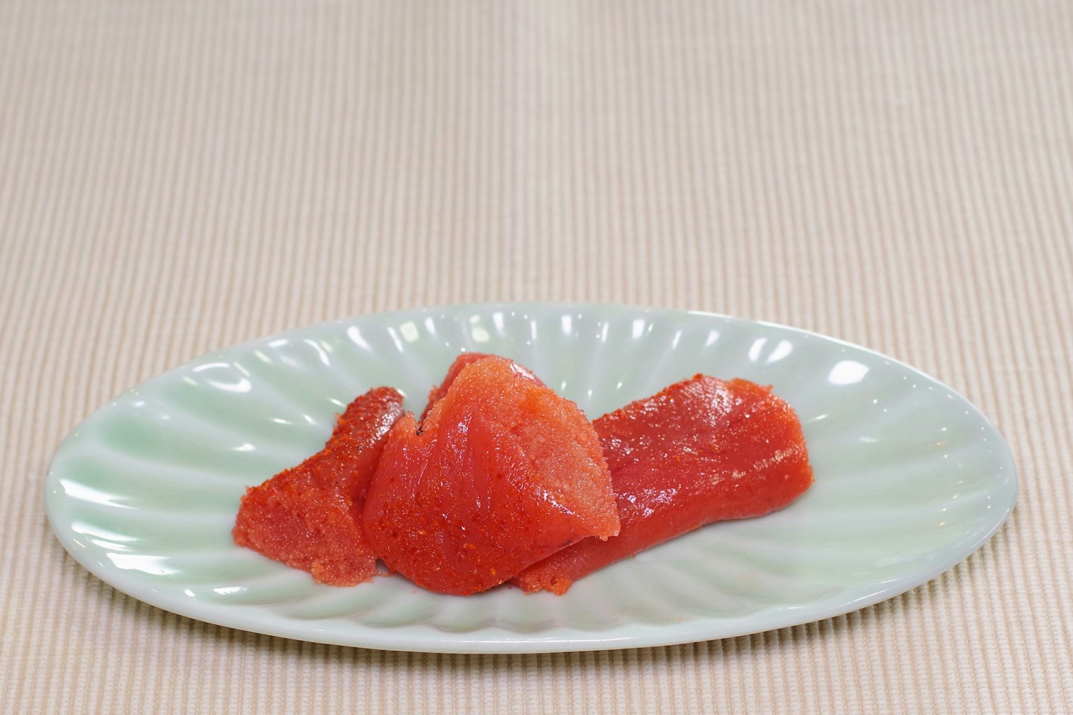 Vibrant red tuna sashimi arranged on a pale green plate