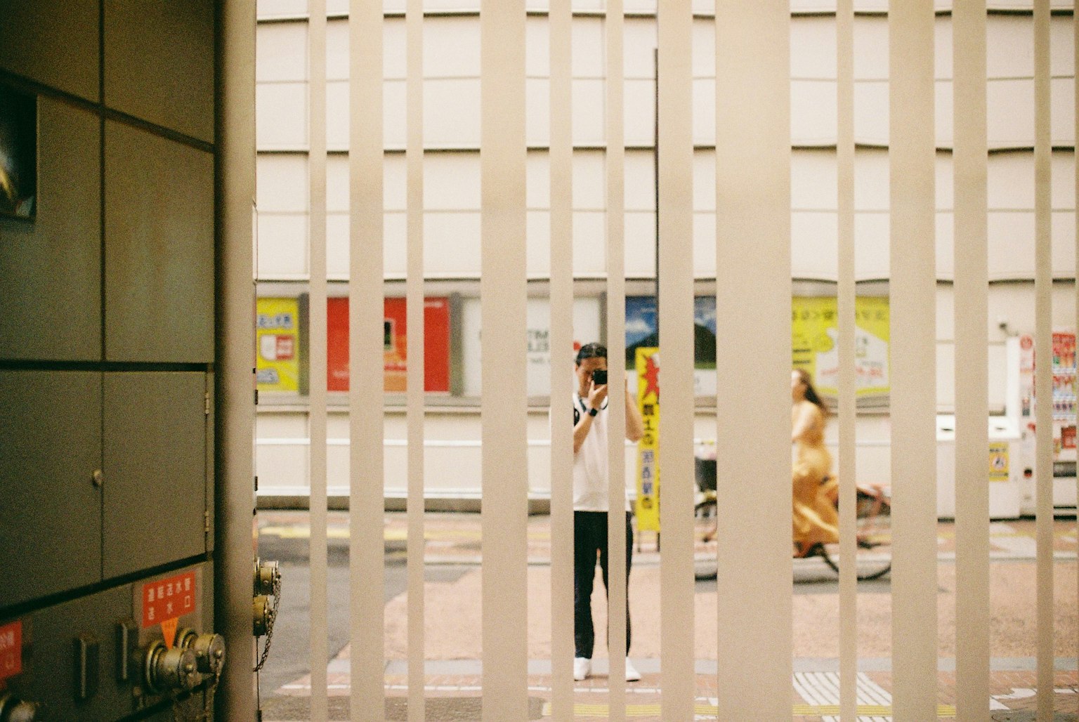 Street view featuring people seen through white striped window