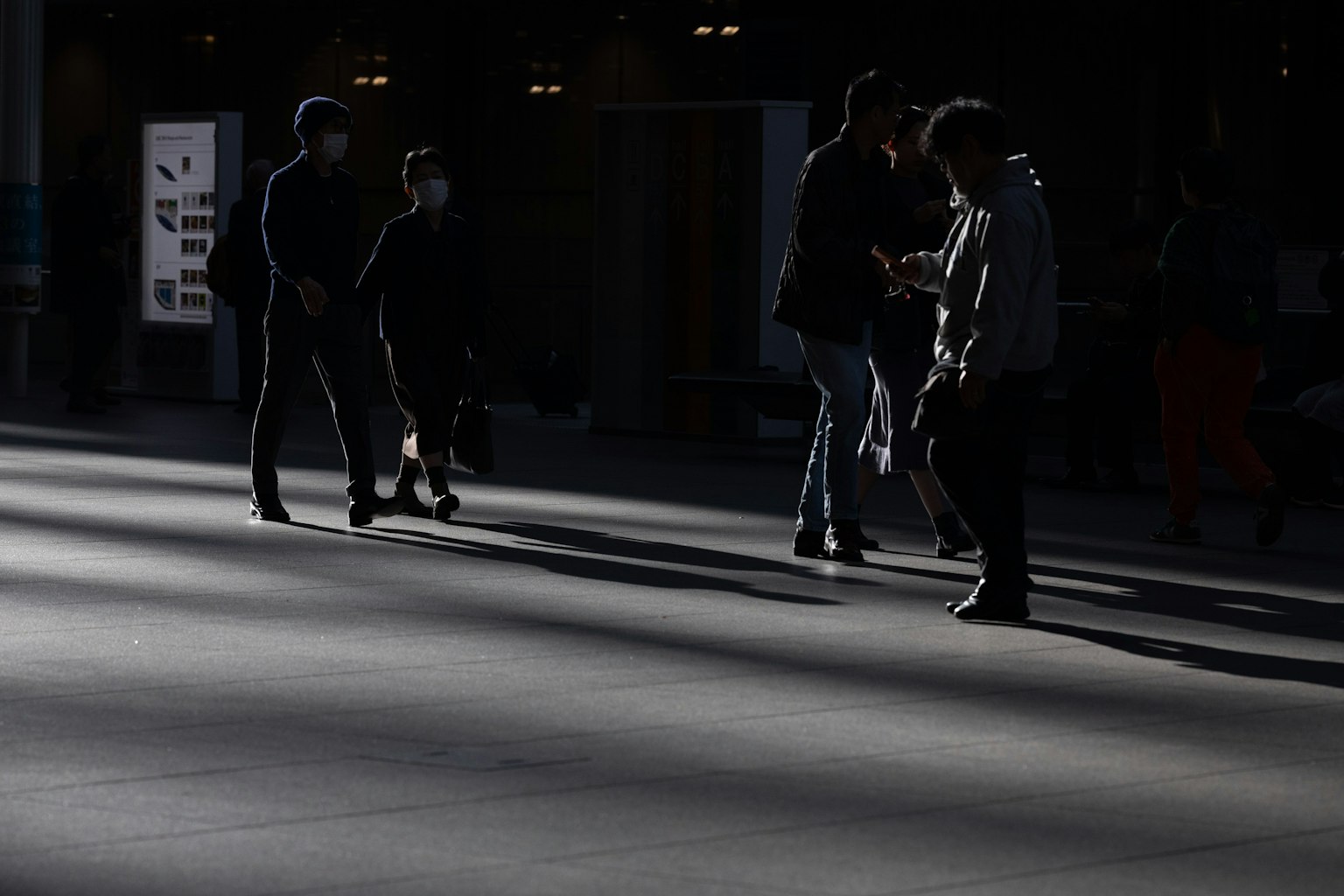 เงาของคนเดินในพื้นที่ที่มีแสงน้อย