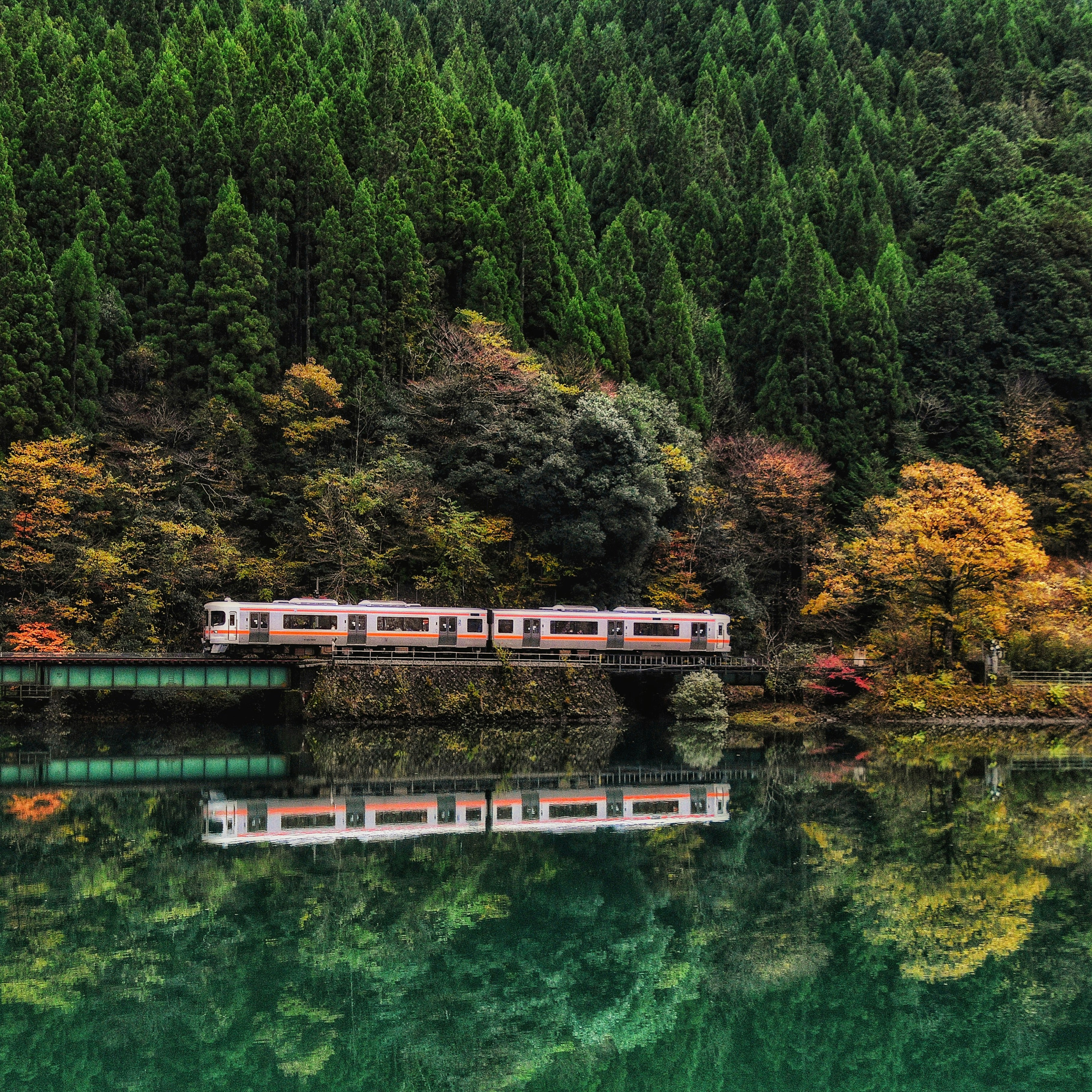 下原大坝湖畔行驶的高山本线列车与锦绣般的群山