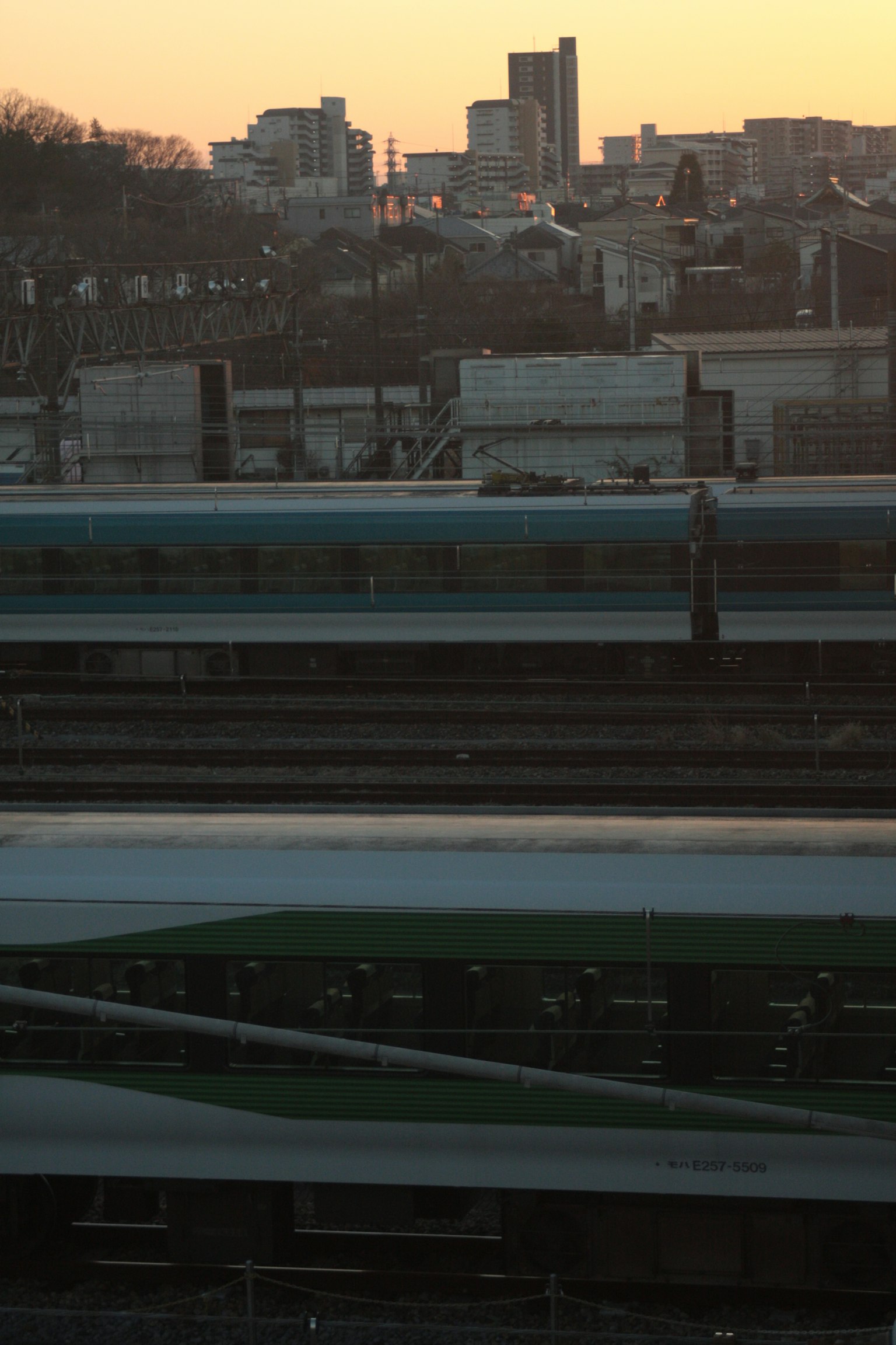 Cityscape at sunset with railway tracks in the foreground