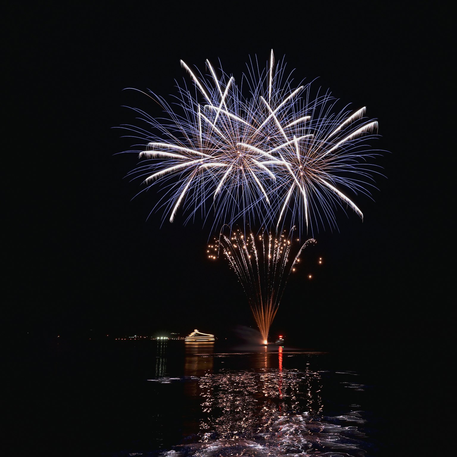 Beautiful fireworks illuminating the night sky reflected on the water