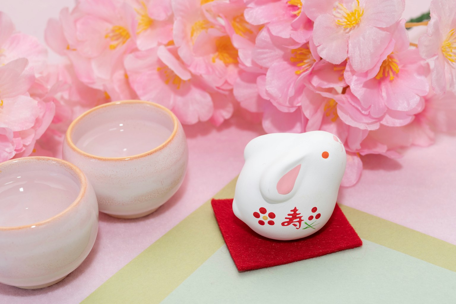 Bố cục đẹp của hoa anh đào, trang trí thỏ trắng và hai chén