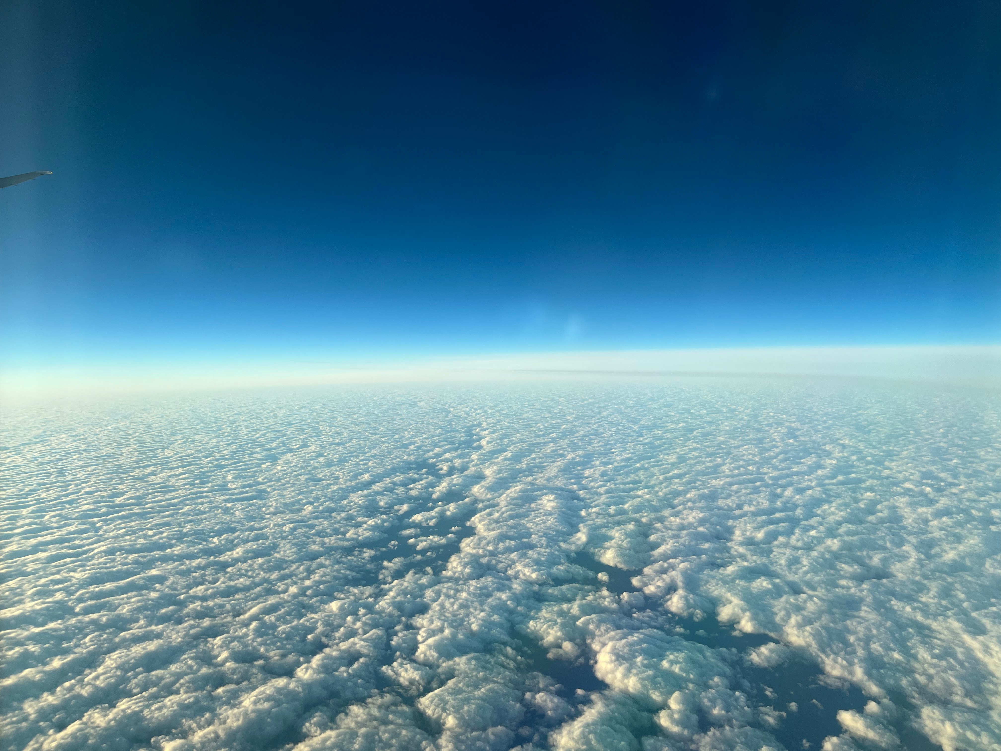 空の青と白い雲の広がりが見える航空写真