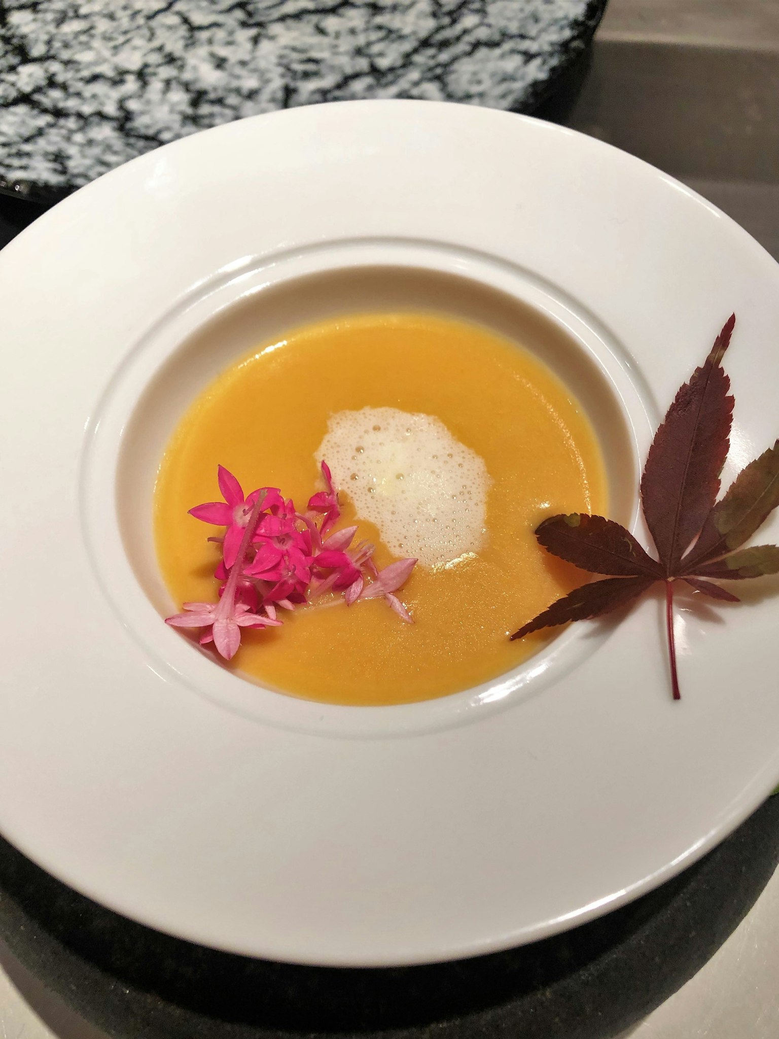 Zuppa cremosa guarnita con fiori e foglie
