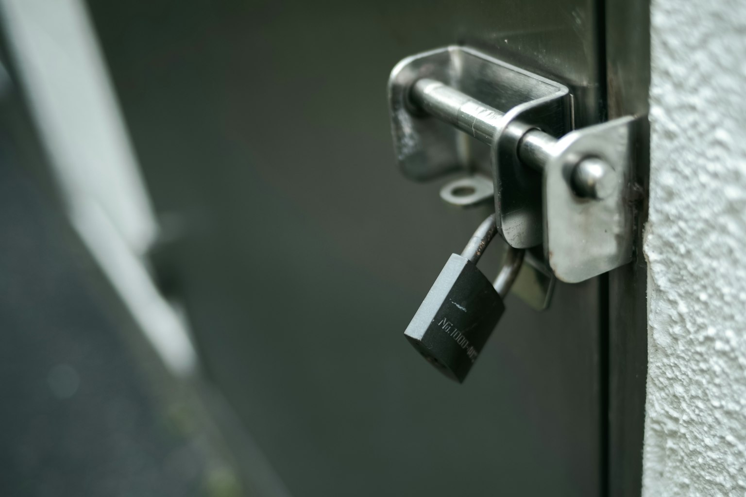 Metal door lock mechanism with a black padlock