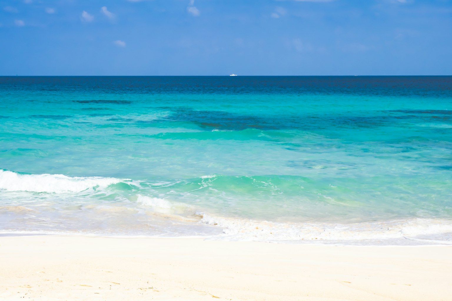 Une belle scène de plage avec une mer bleue et un rivage de sable blanc