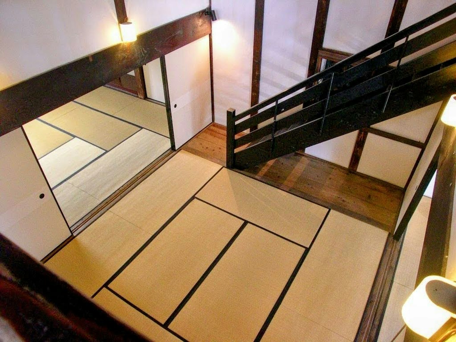 Innenraum eines japanischen Zimmers mit Tatami-Boden Holztreppe und Spiegelwand