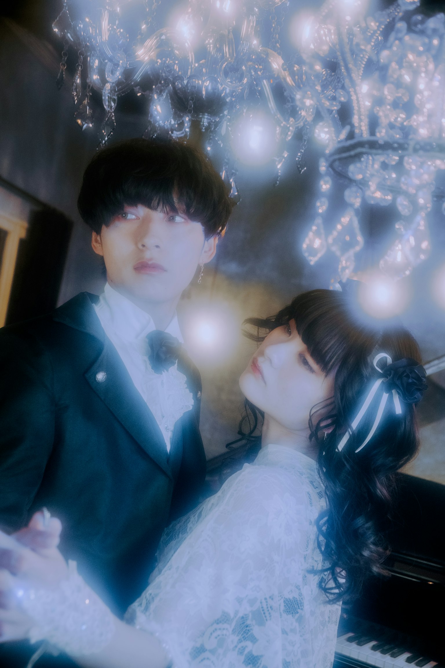 우아한 복장을 한 커플이 샹들리에 아래에서 춤추고 있는 모습