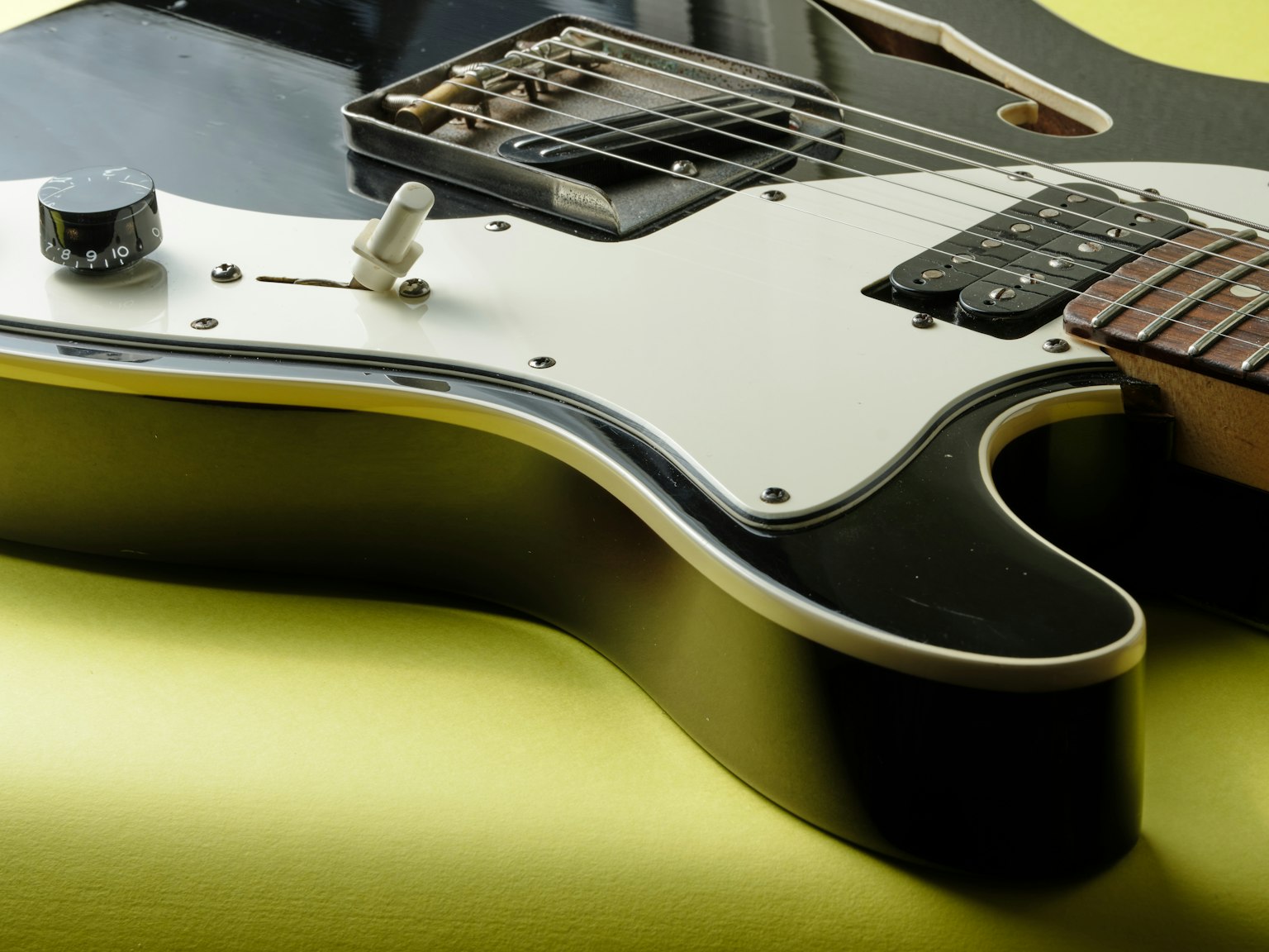 Side view of a black electric guitar showcasing body details