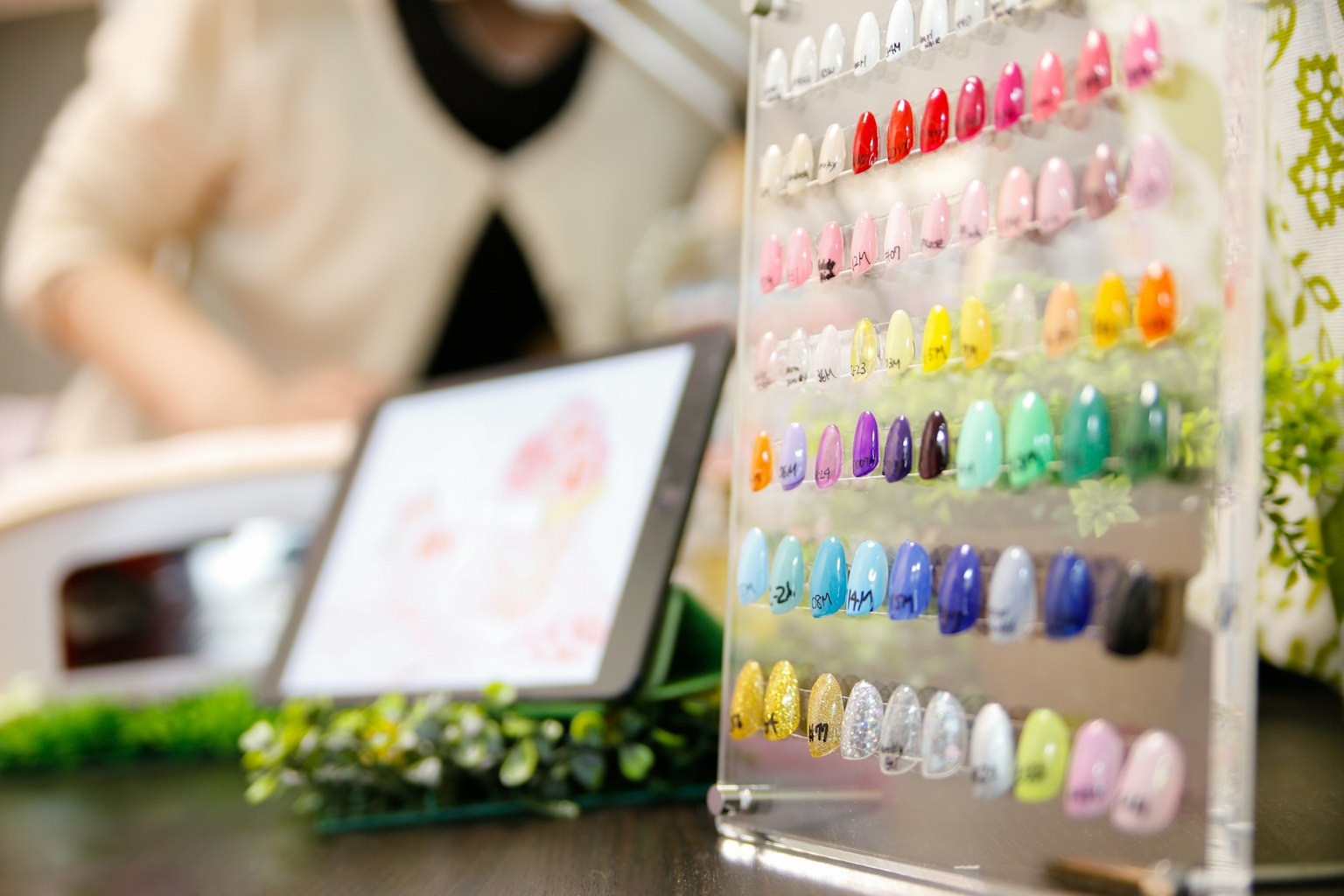 在美甲店展示的透明架子上的彩色指甲油样品