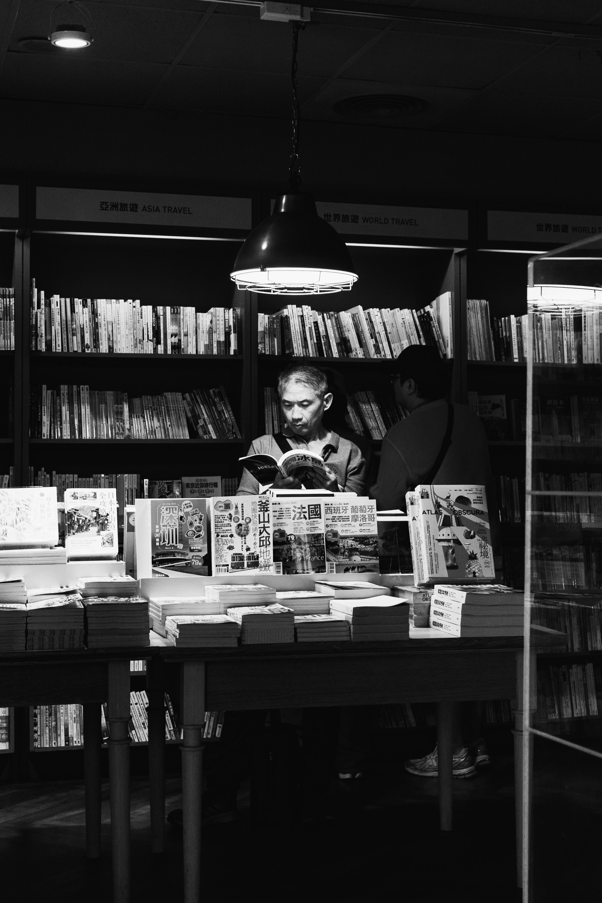 本棚の前で本を読む人がいる書店の店内