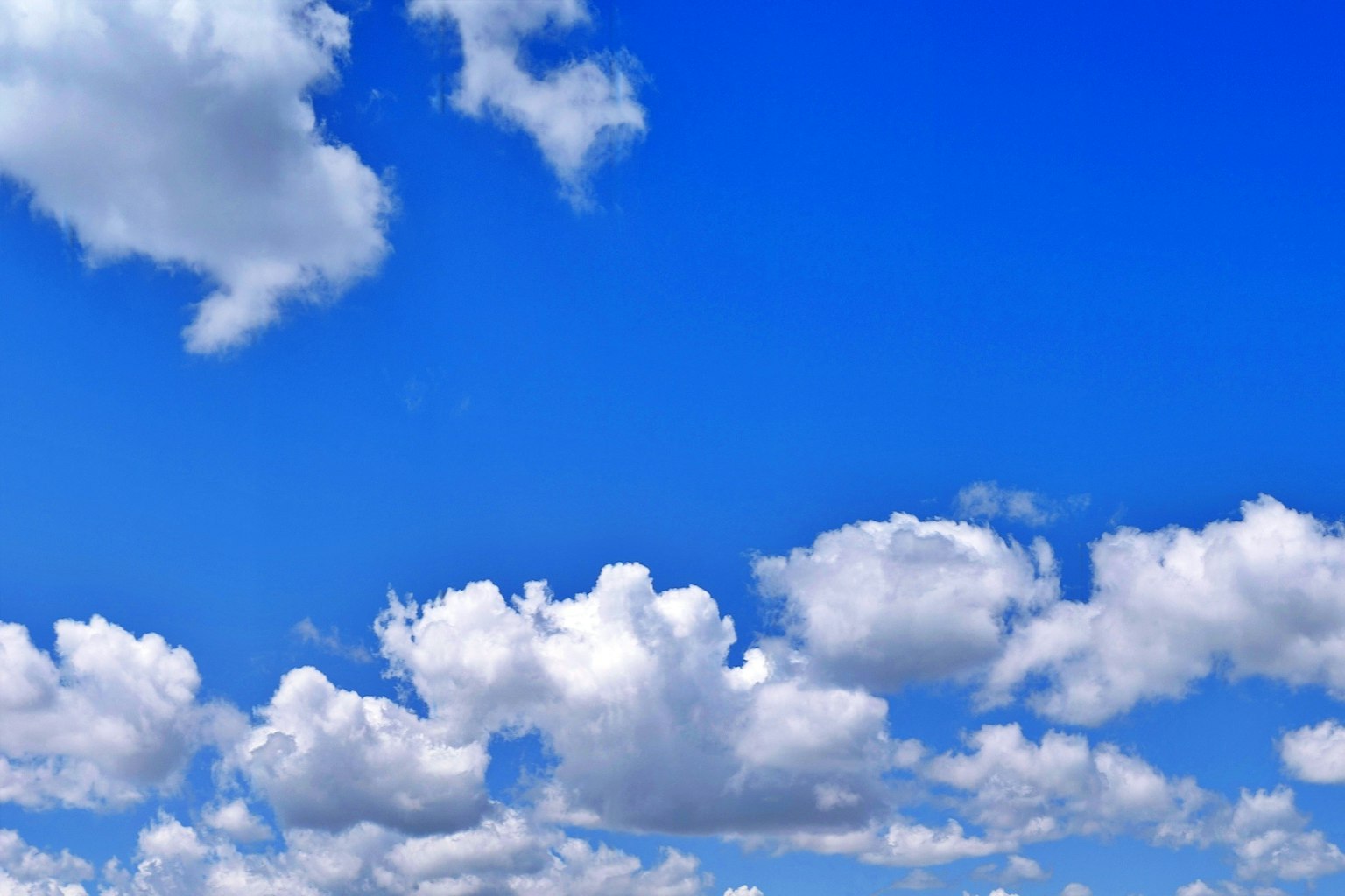 Awan putih mengapung di langit biru yang cerah