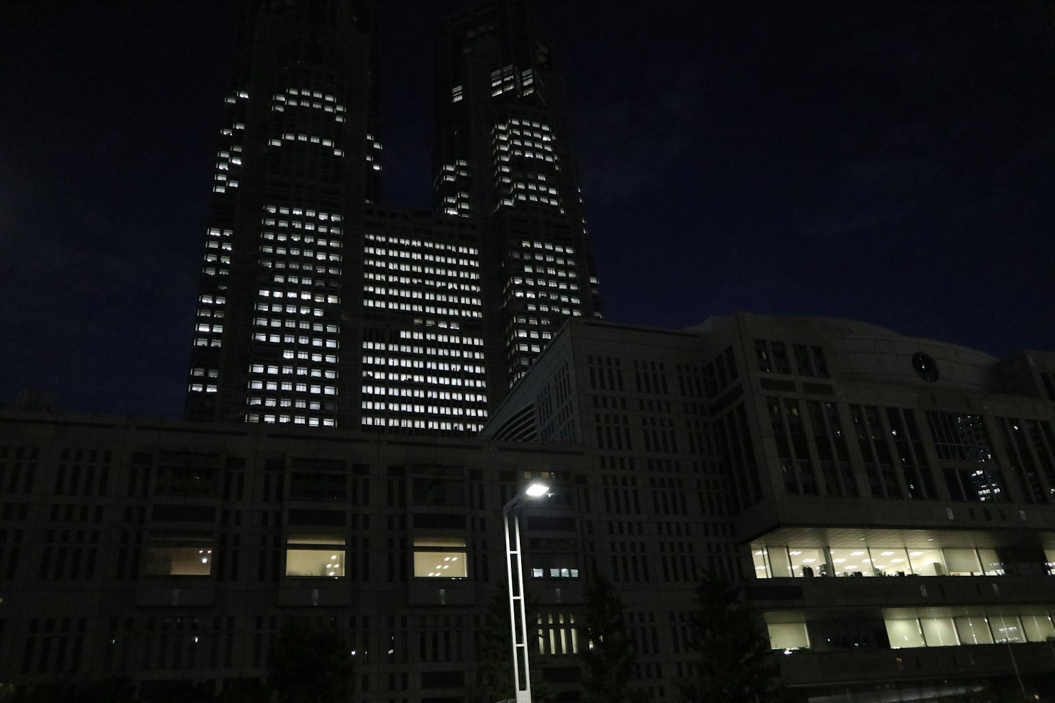 Tokio Hochhäuser bei Nacht mit den beleuchteten Zwillings-Türmen des Gebäudes der Stadtregierung von Tokio