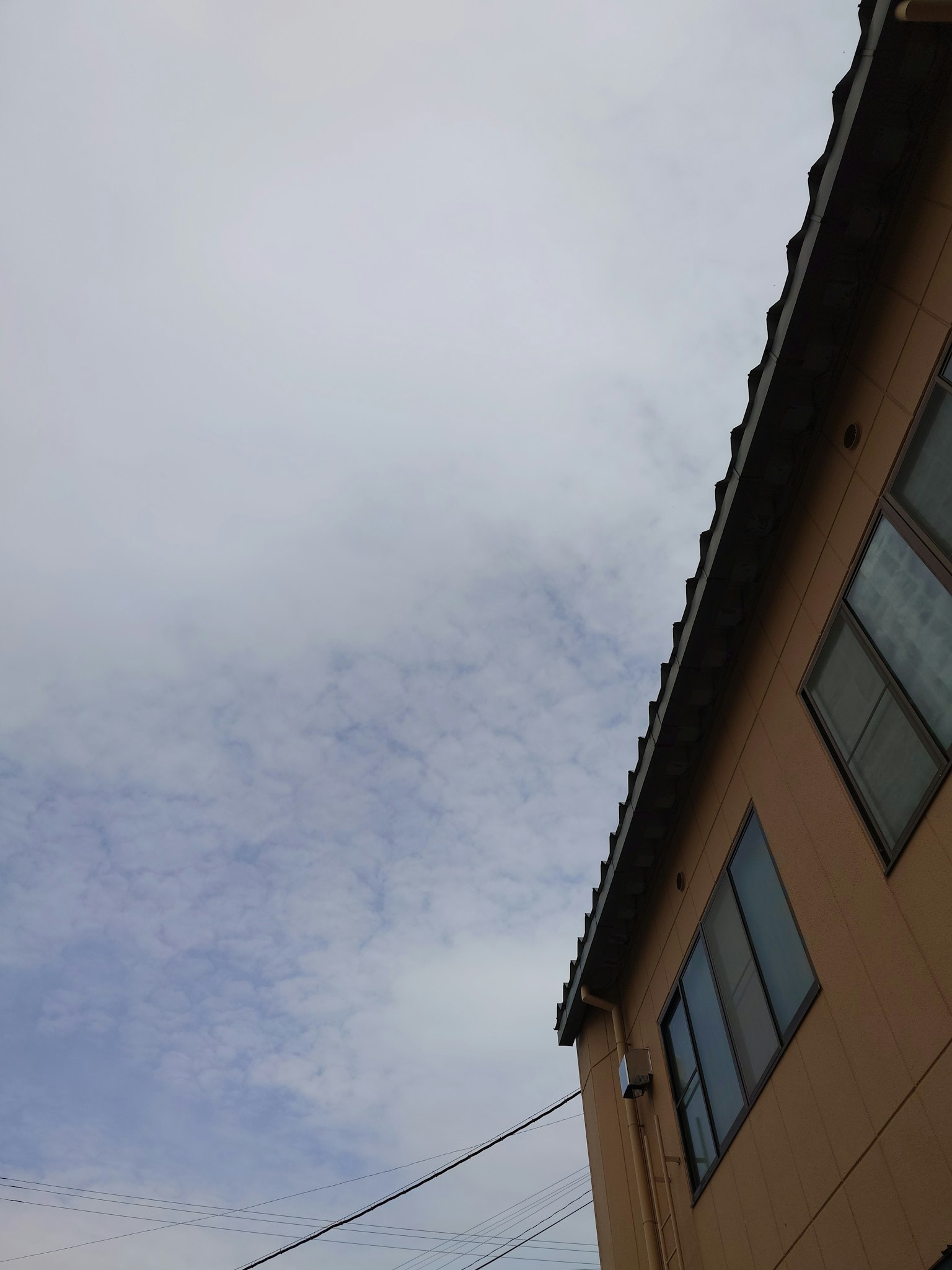 Cloudy sky with part of a house visible
