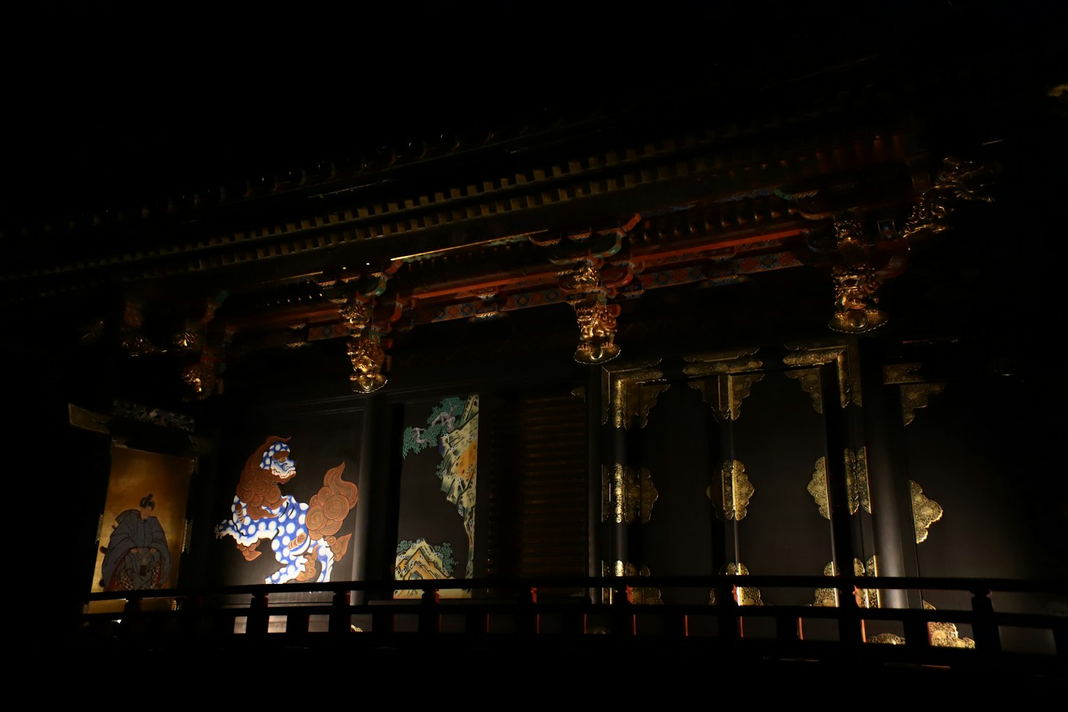 Traditionelles japanisches Gebäude mit beleuchteten Wandmalereien und kunstvollen Details in der Dunkelheit