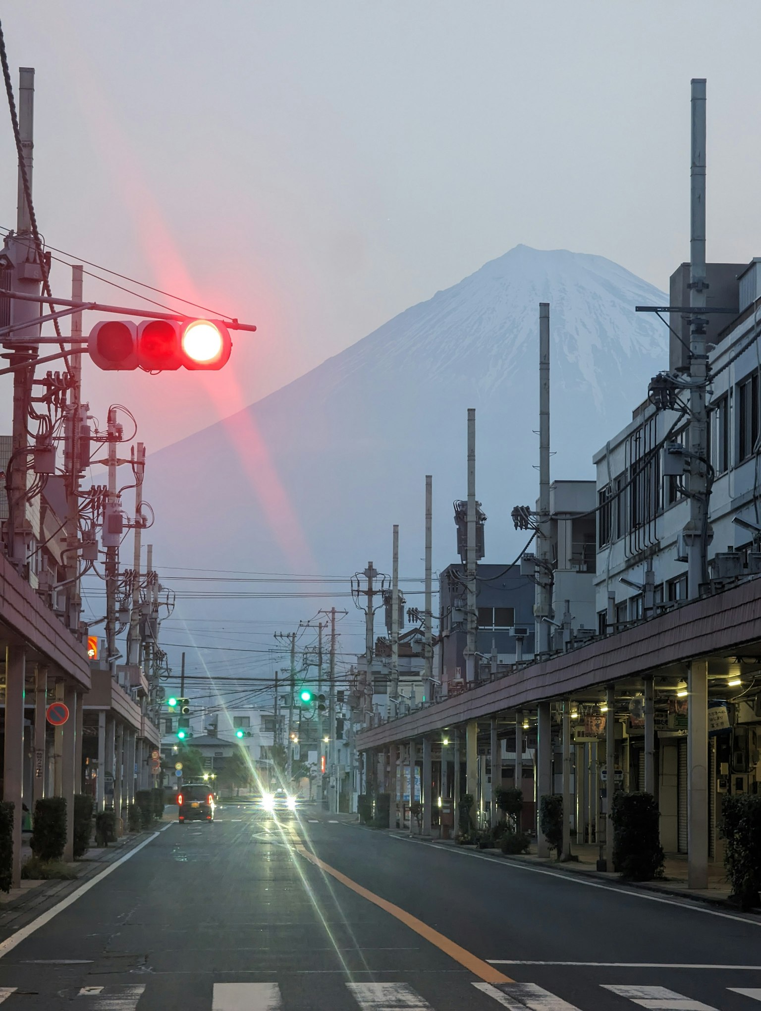 Street view with Mount Fuji in the background red and green traffic lights