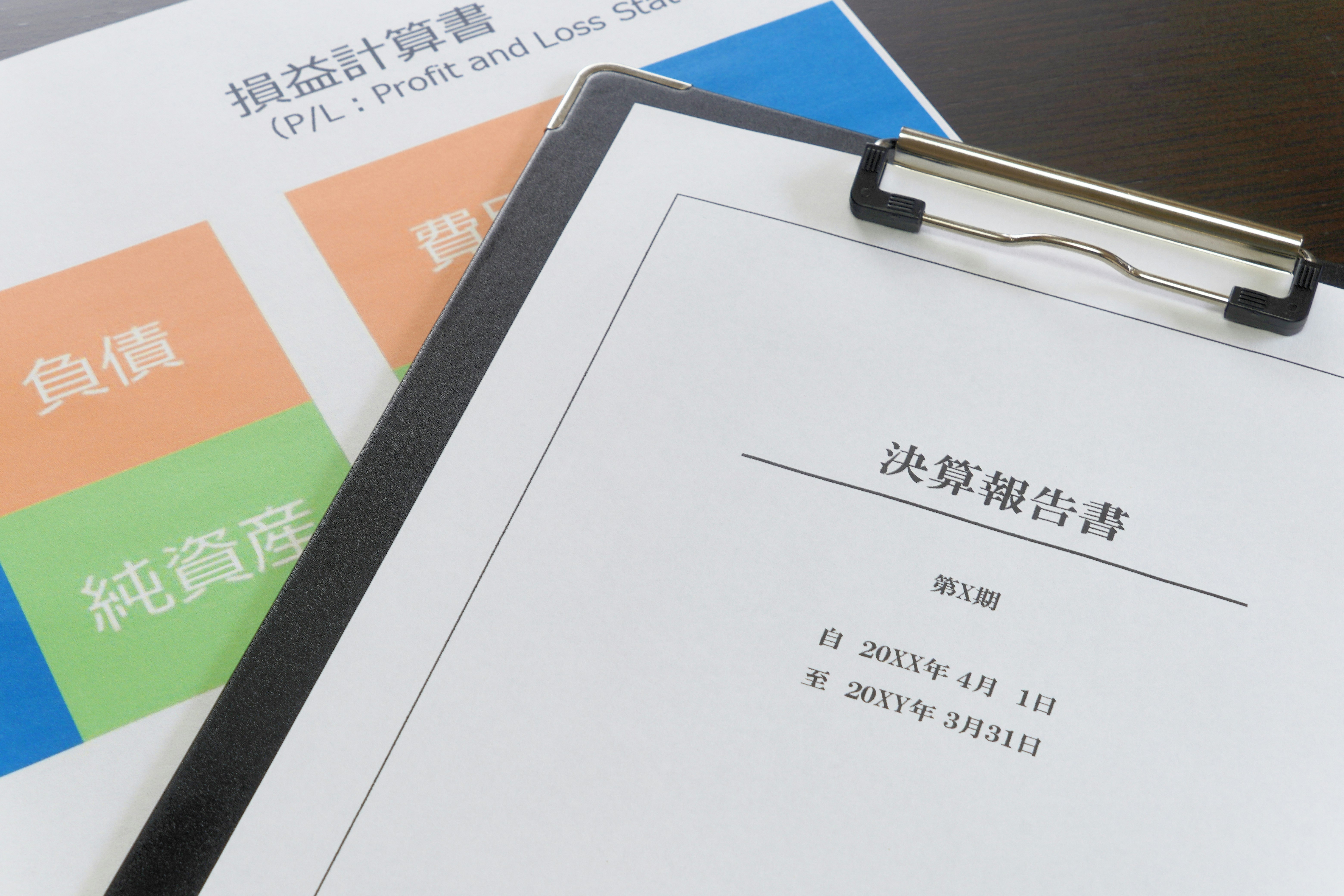 書類とクリップボードに挟まれた決算書類の一部