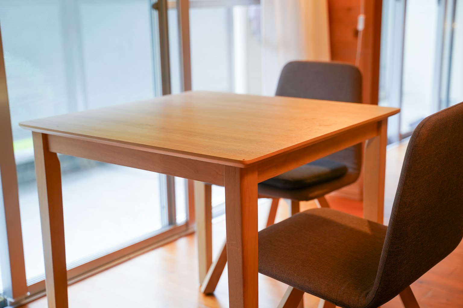 Helles Interieur mit einem Holztisch und zwei Stühlen