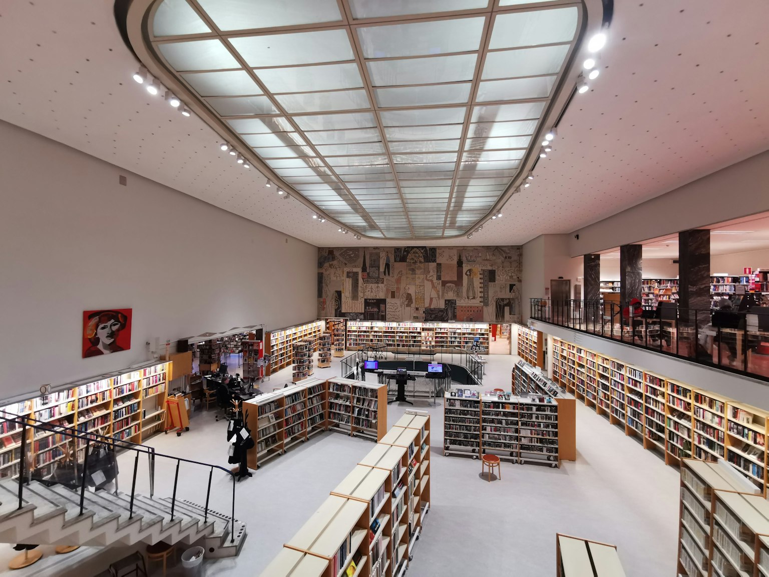 Interno spazioso di una biblioteca moderna con file di scaffali e un'area di lettura tranquilla