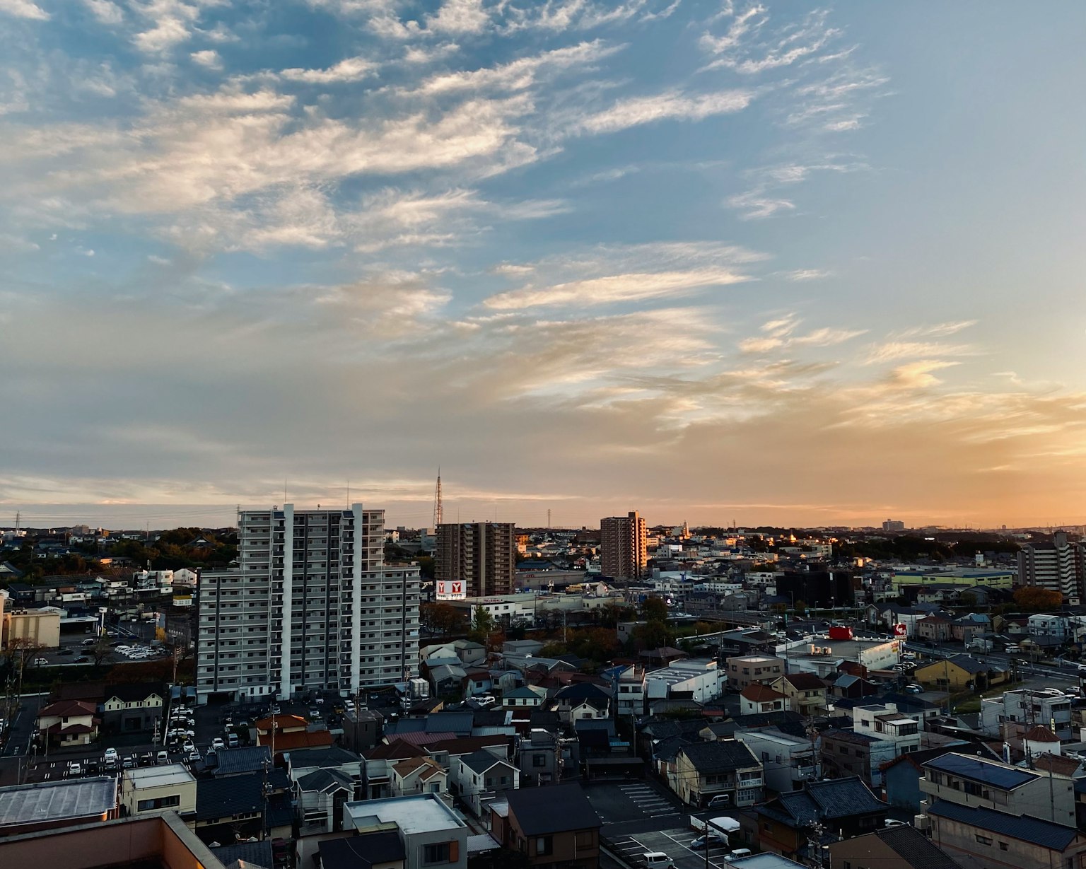 Stadtbild bei Sonnenuntergang mit verstreuten Wolken